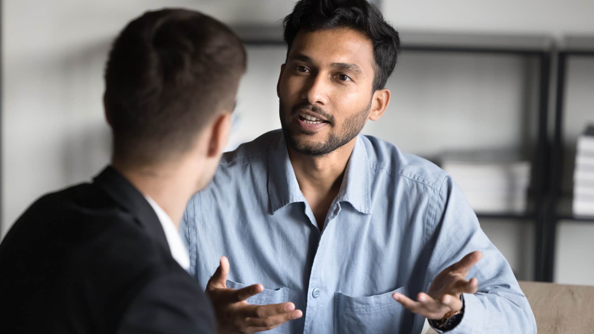 Man having a serious conversation with a co-worker.