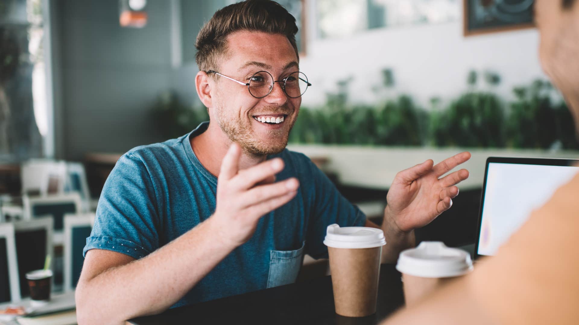 Man smiling and talking to a woman across the table