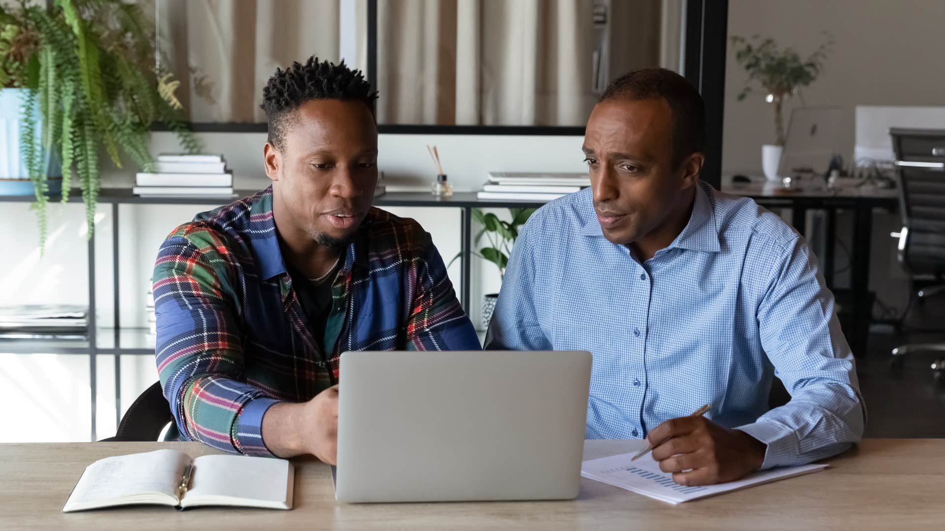 Two men looking at a laptop together