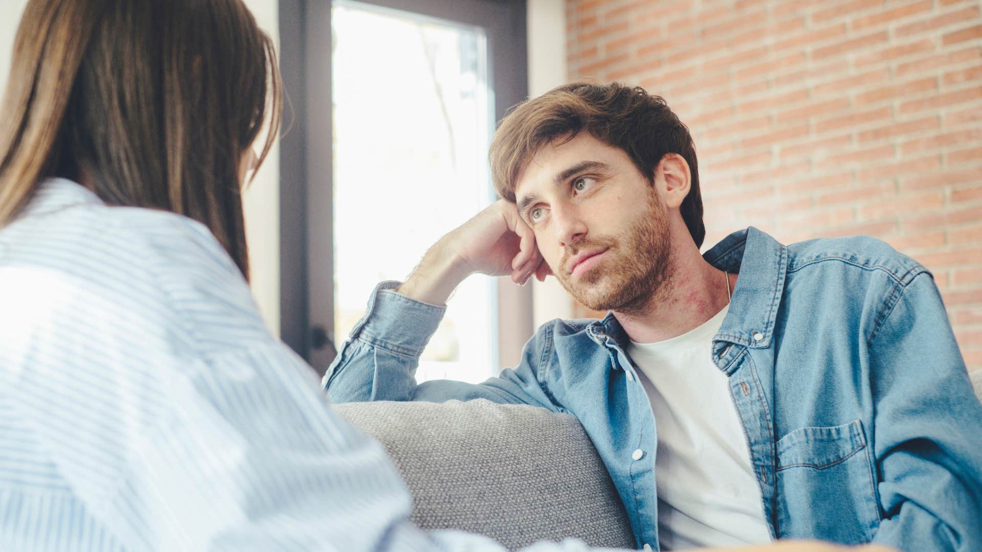 Man looking intently at his partner on the couch