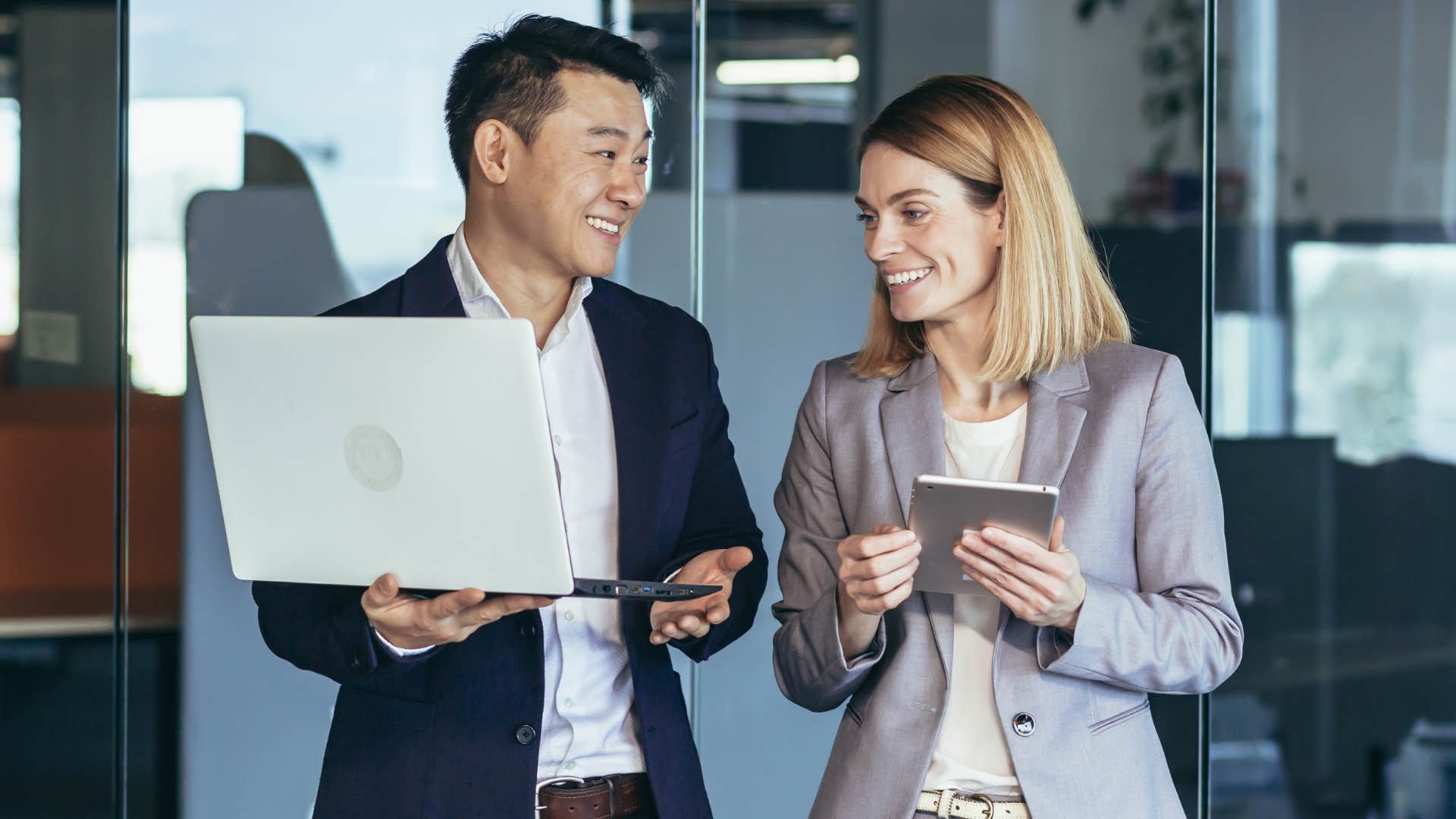 Co-workers smiling and talking together in an office