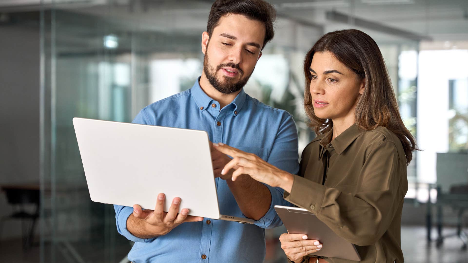 Co-workers talking and pointing at a laptop together