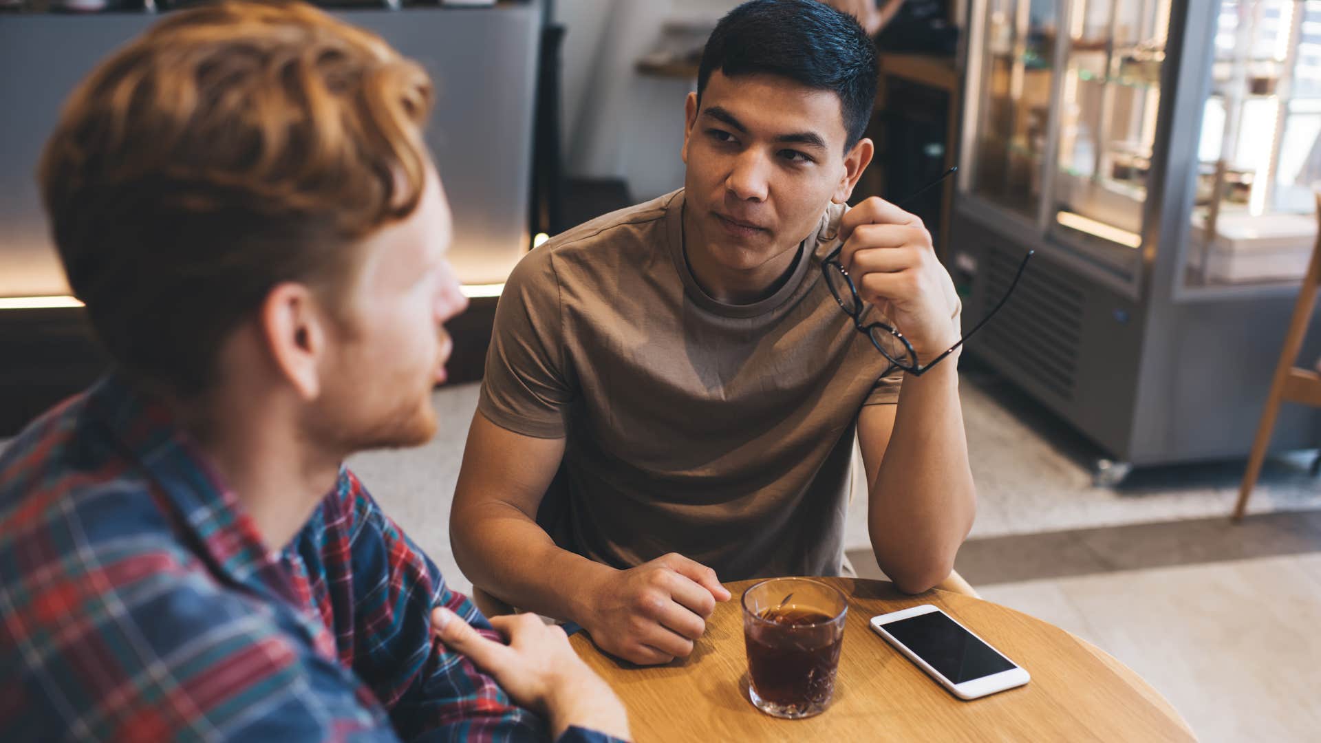 Two men talking in a coffee shop.