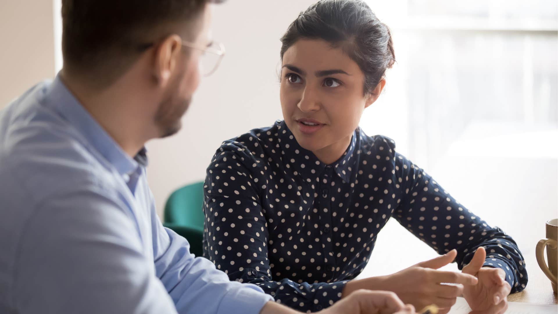 Woman having a conversation with a male co-worker.