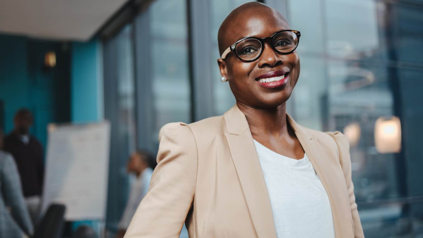 Confident professional woman smiling in an office.