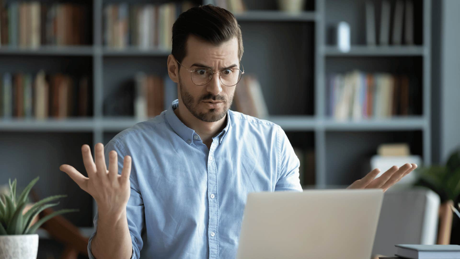 man complaining as he looks at his laptop