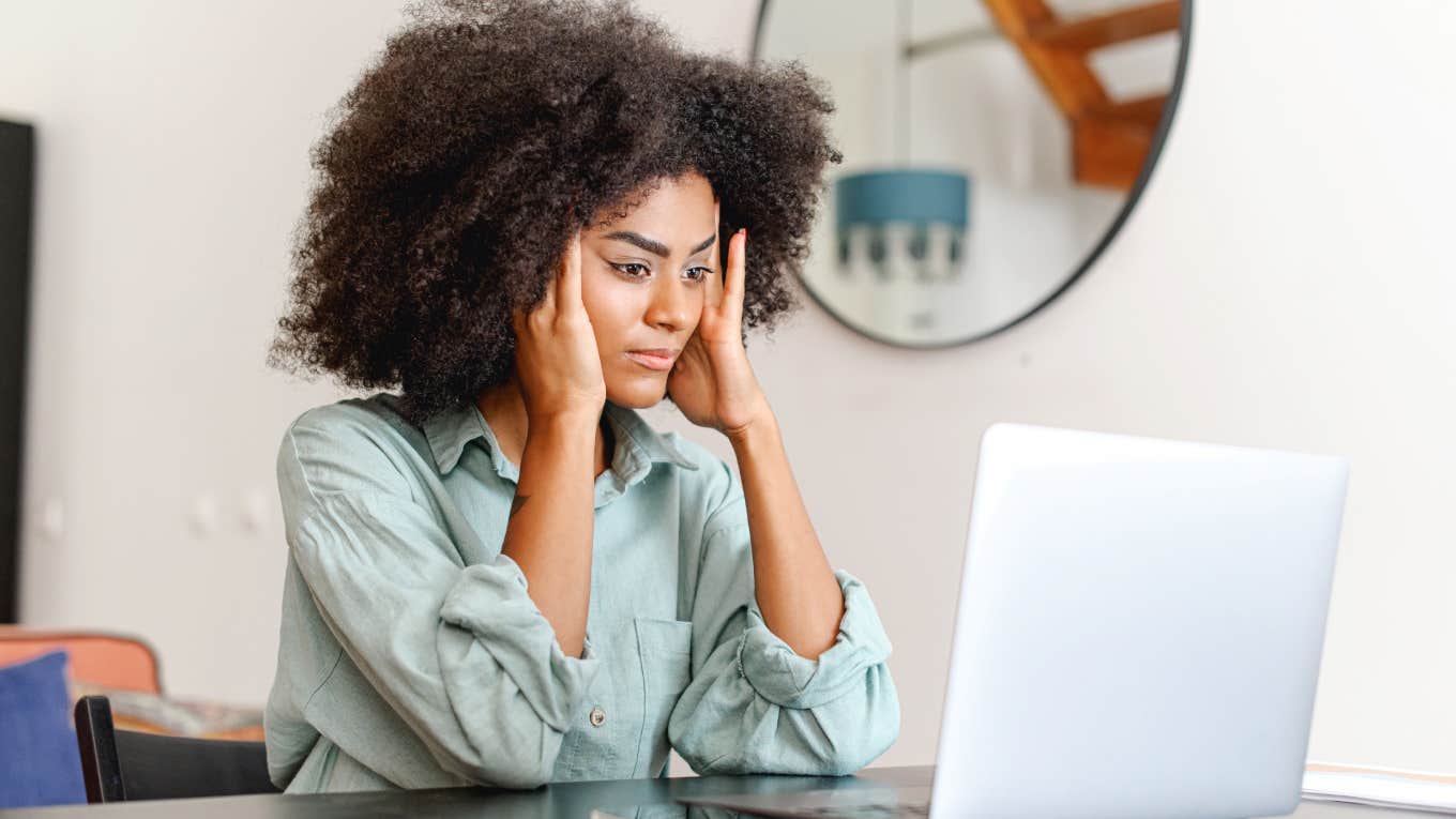 Confused woman looking at laptop screen in despair