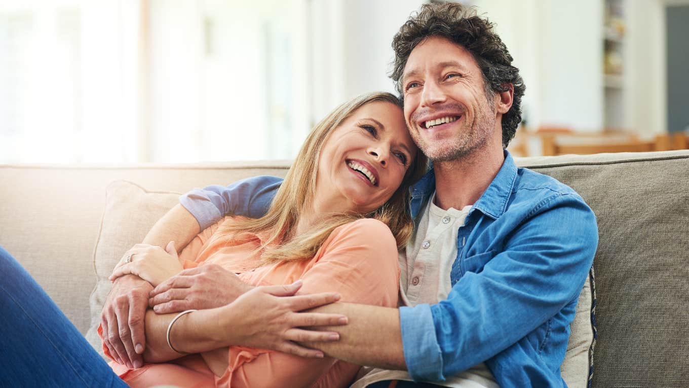 good husband hugging wife on couch