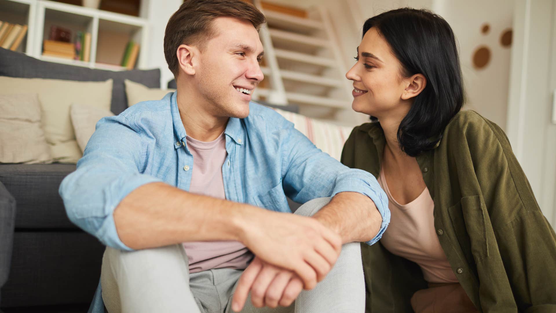 Man smiling at his partner on the couch.