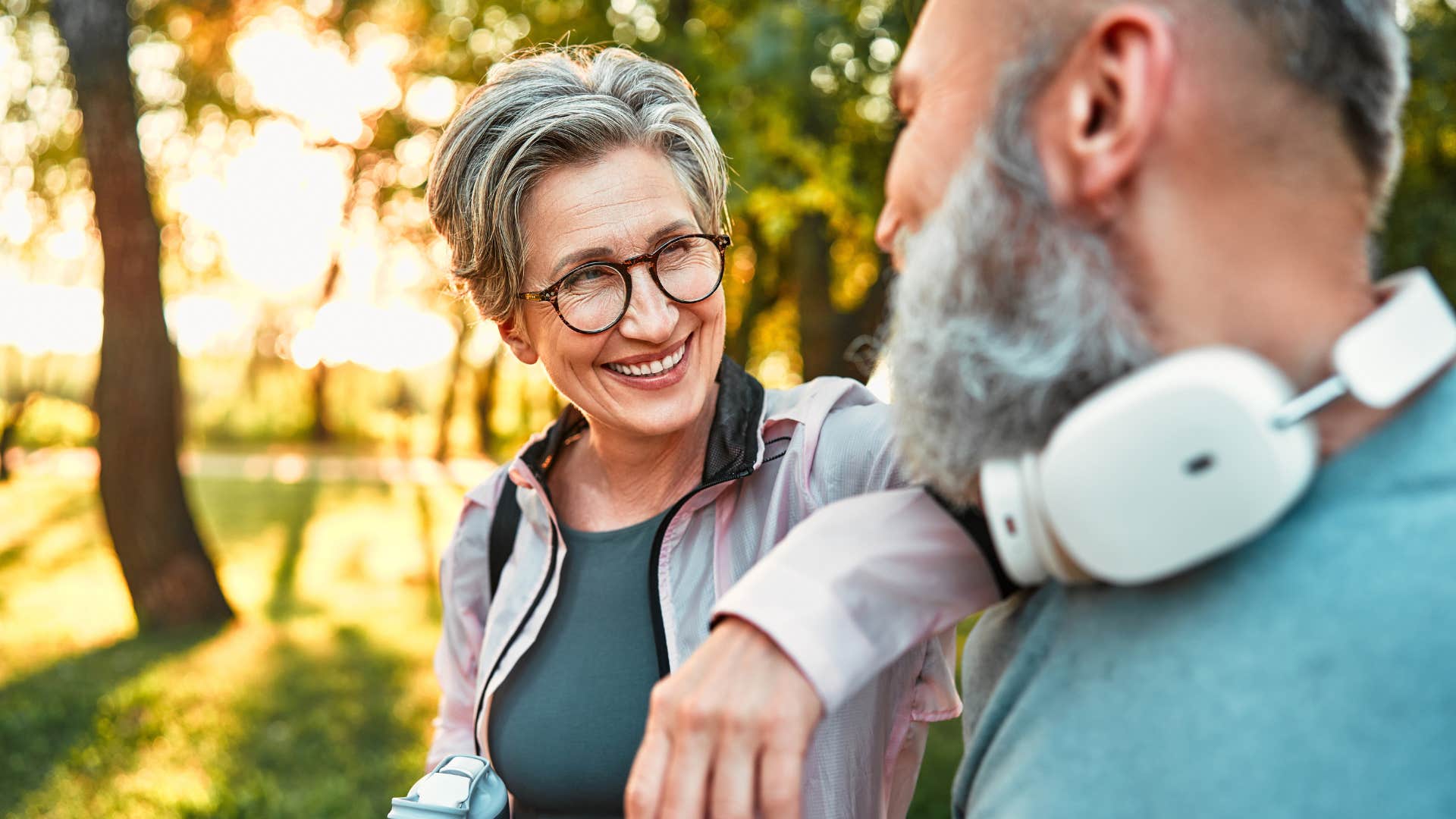 Woman smiling while resting her arm on her partner's shoulder.