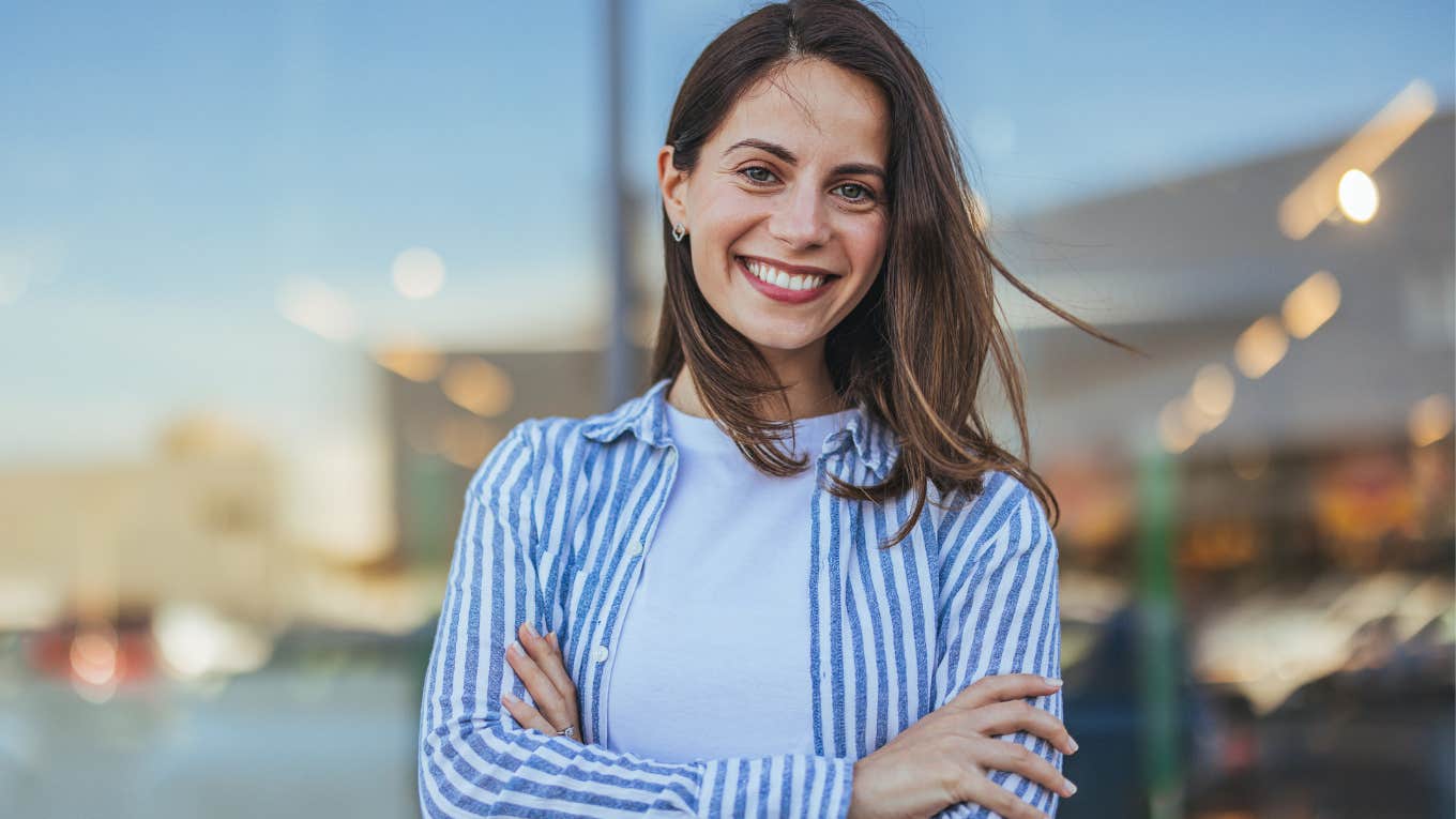 happy charismatic woman smiling with arms crossed