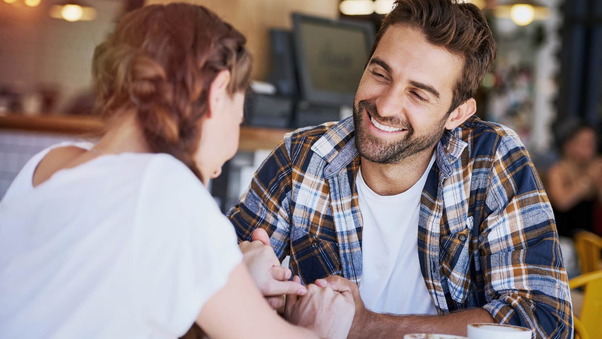 Man smiling at a woman across the table.