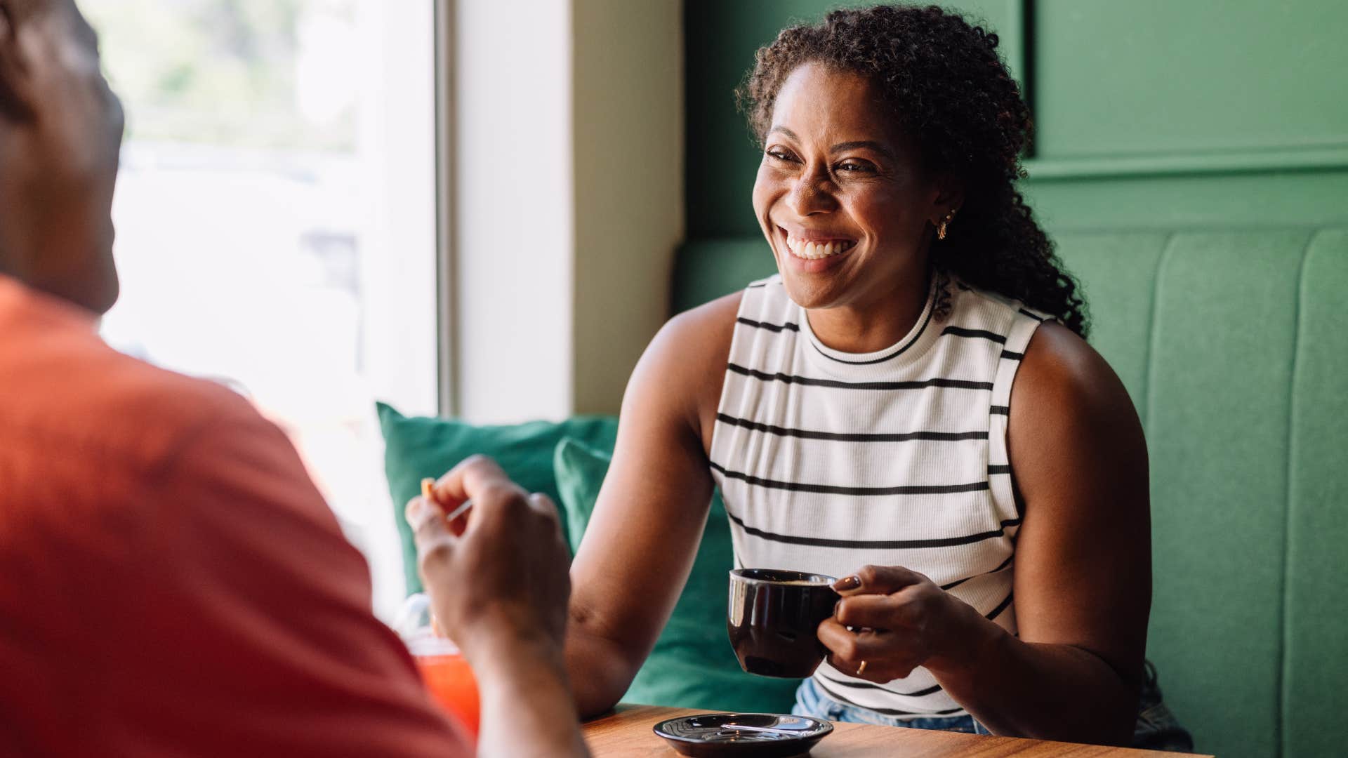 Woman smiling at a man across from her.