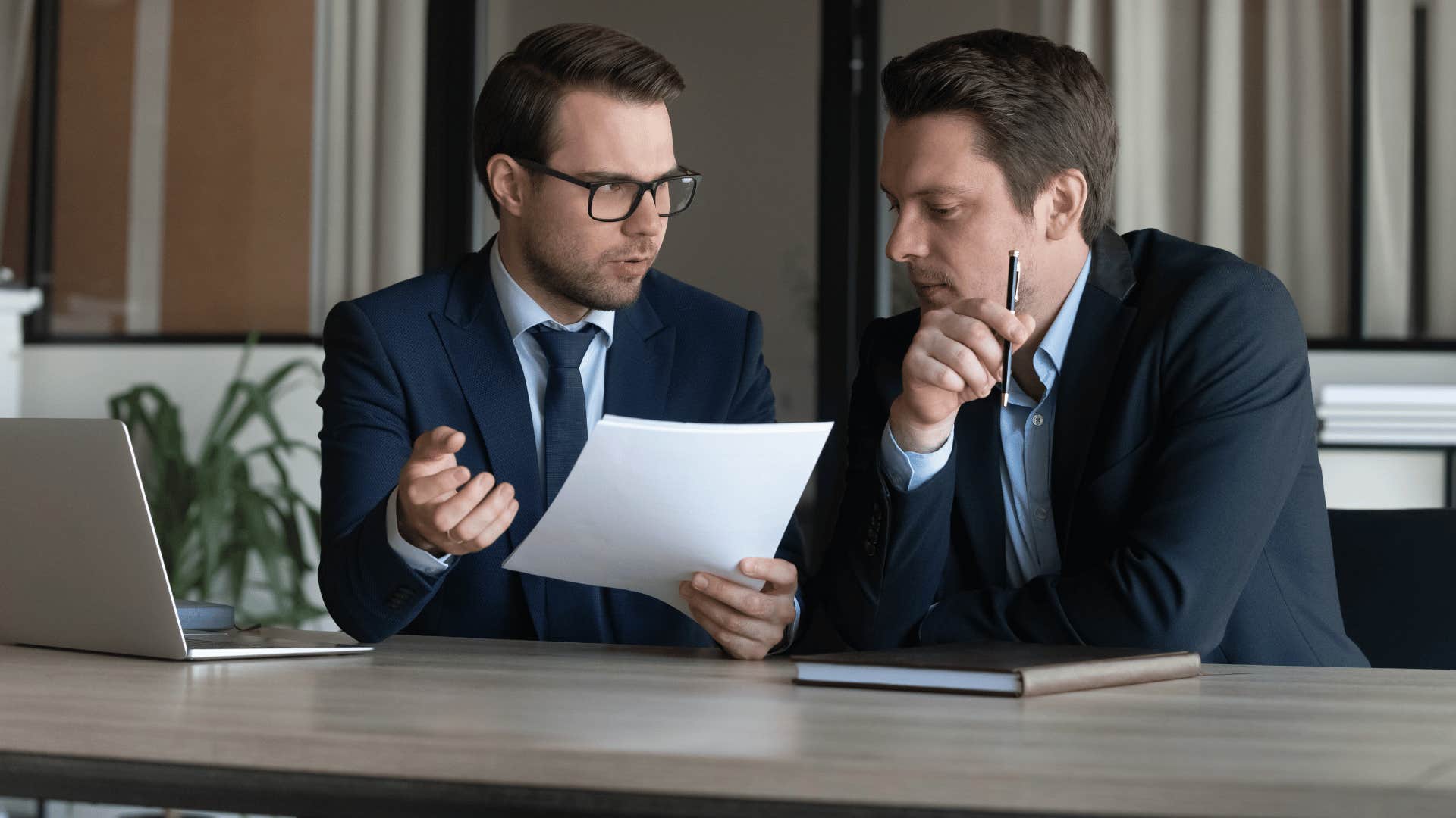 two men discussing document 