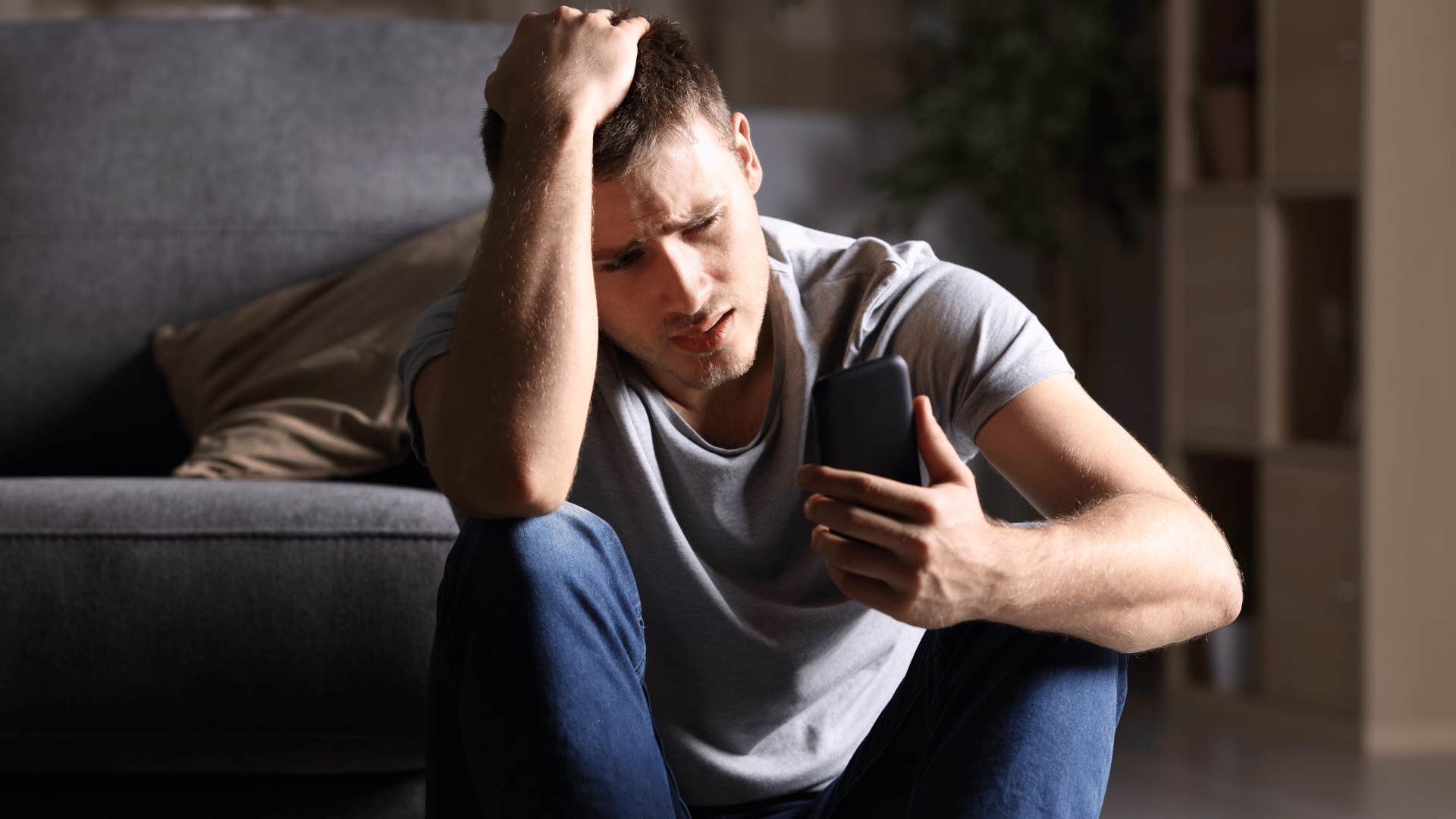 man looking at phone stressed