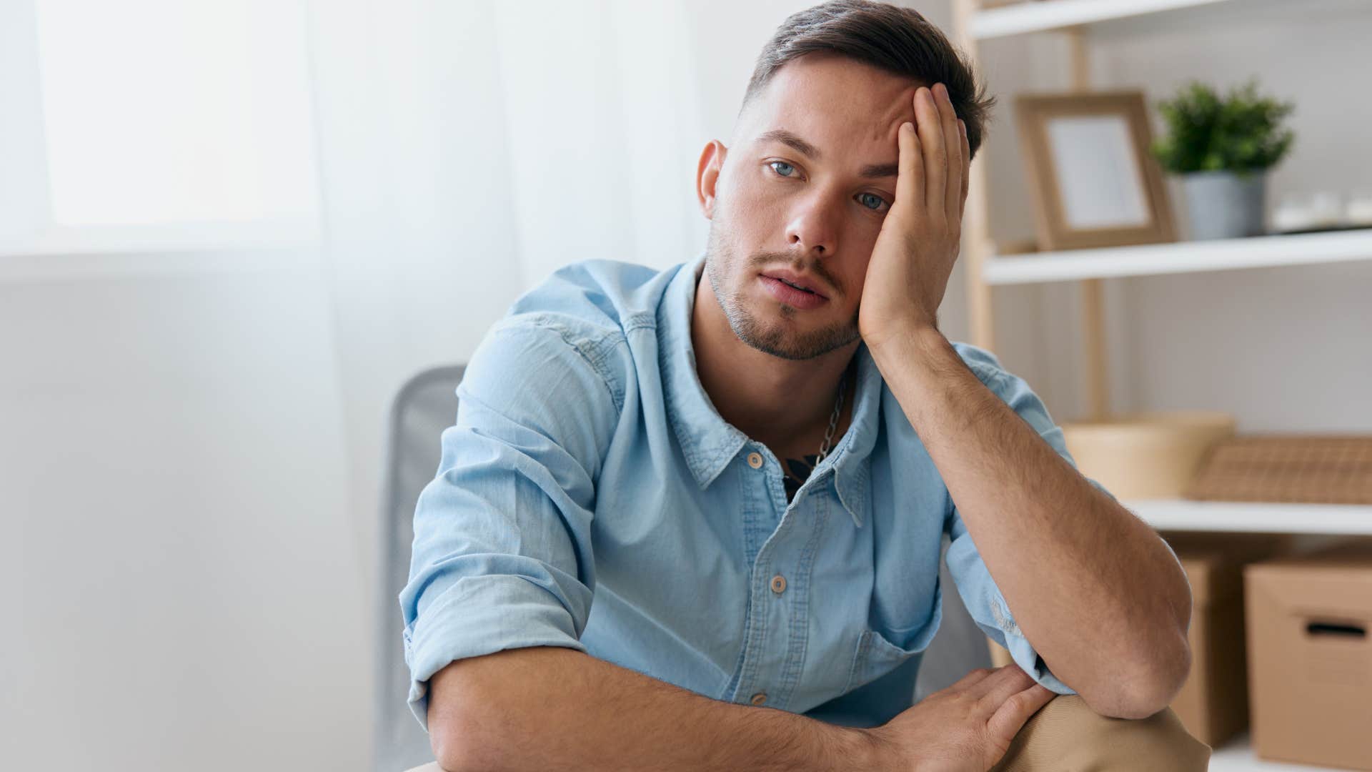 Man holding his head and looking annoyed