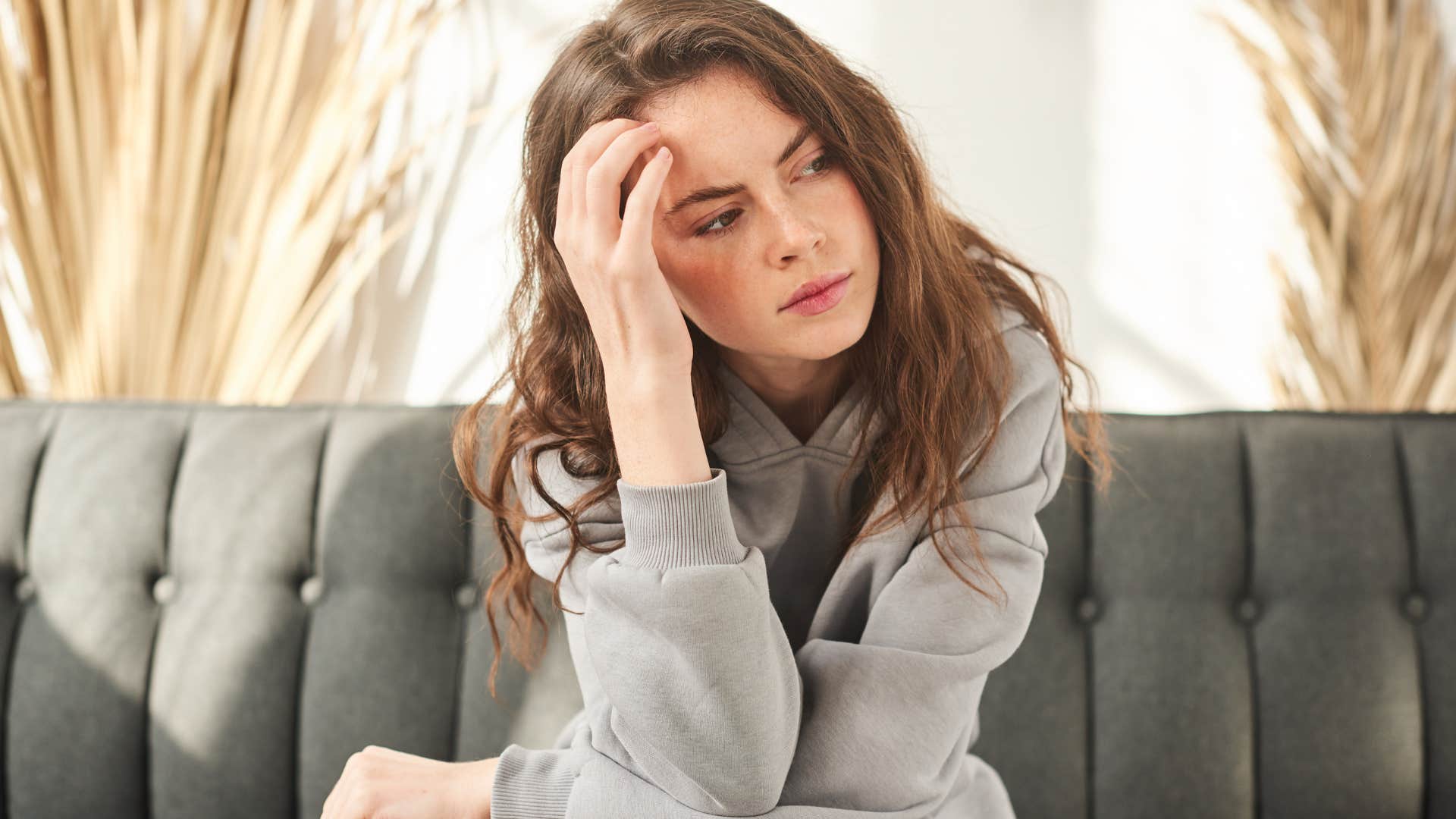 Woman looking annoyed with her head in her hands