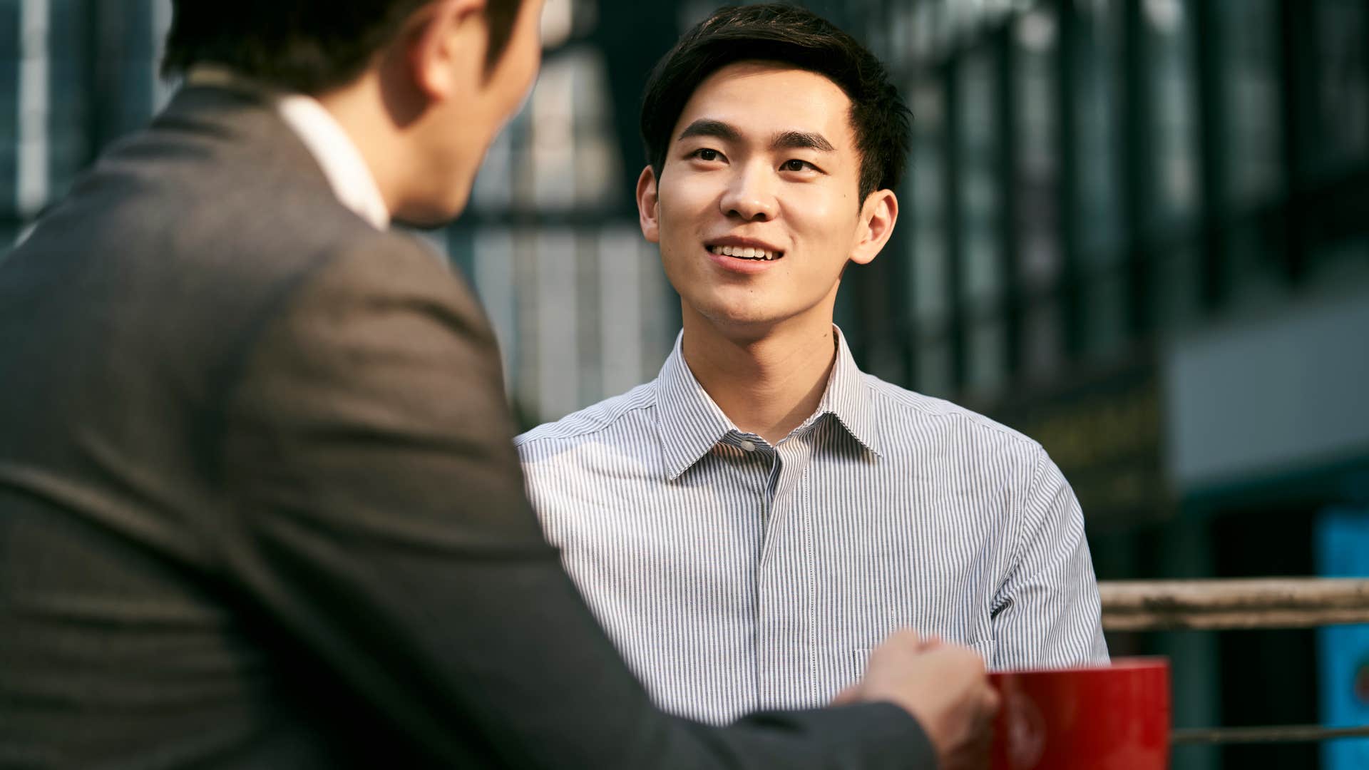 Man smiling and talking to his friend