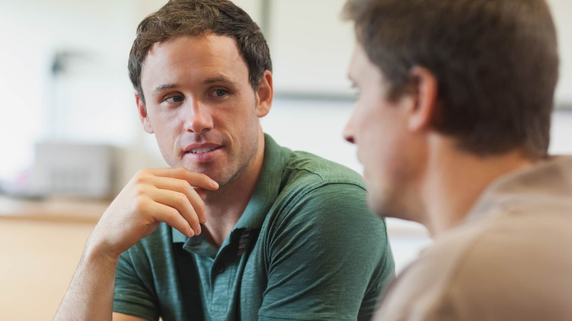 Man smiling and talking to his friend