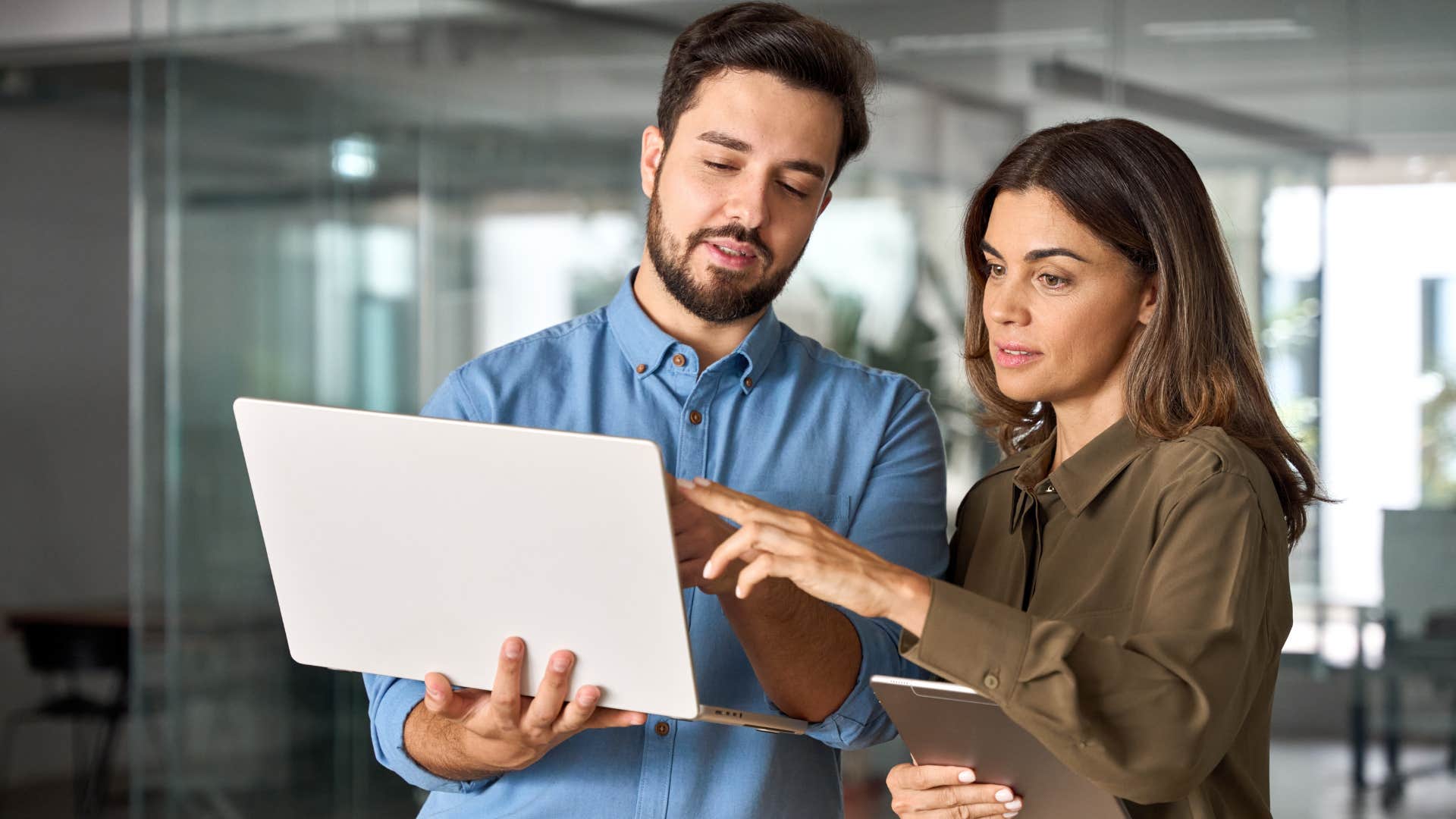 Co-workers looking at a laptop together in an office