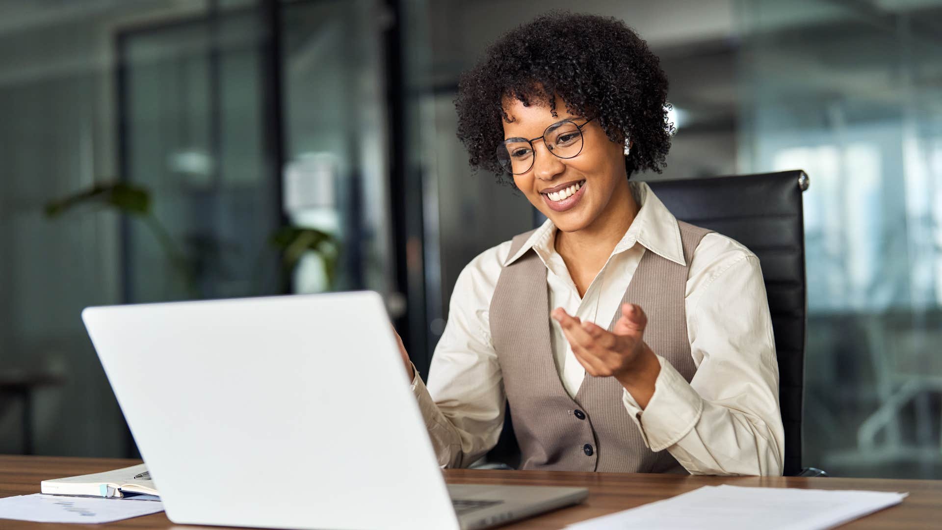 Woman smiling and talking to someone on her laptop