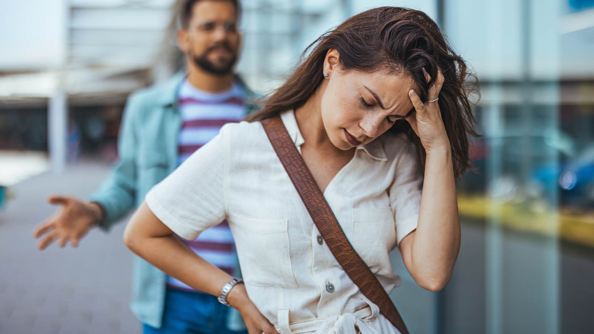 Woman turned away from her angry partner outside