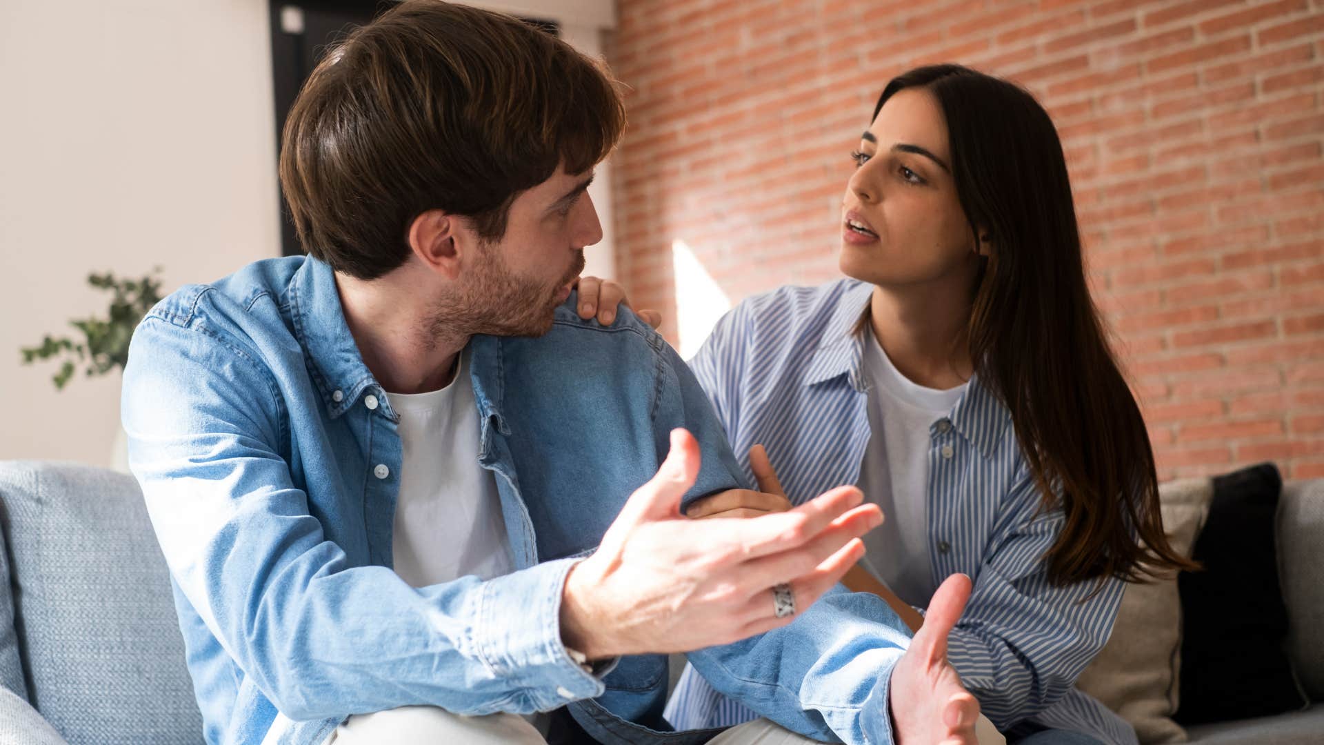 Couple arguing while sitting together on a couch