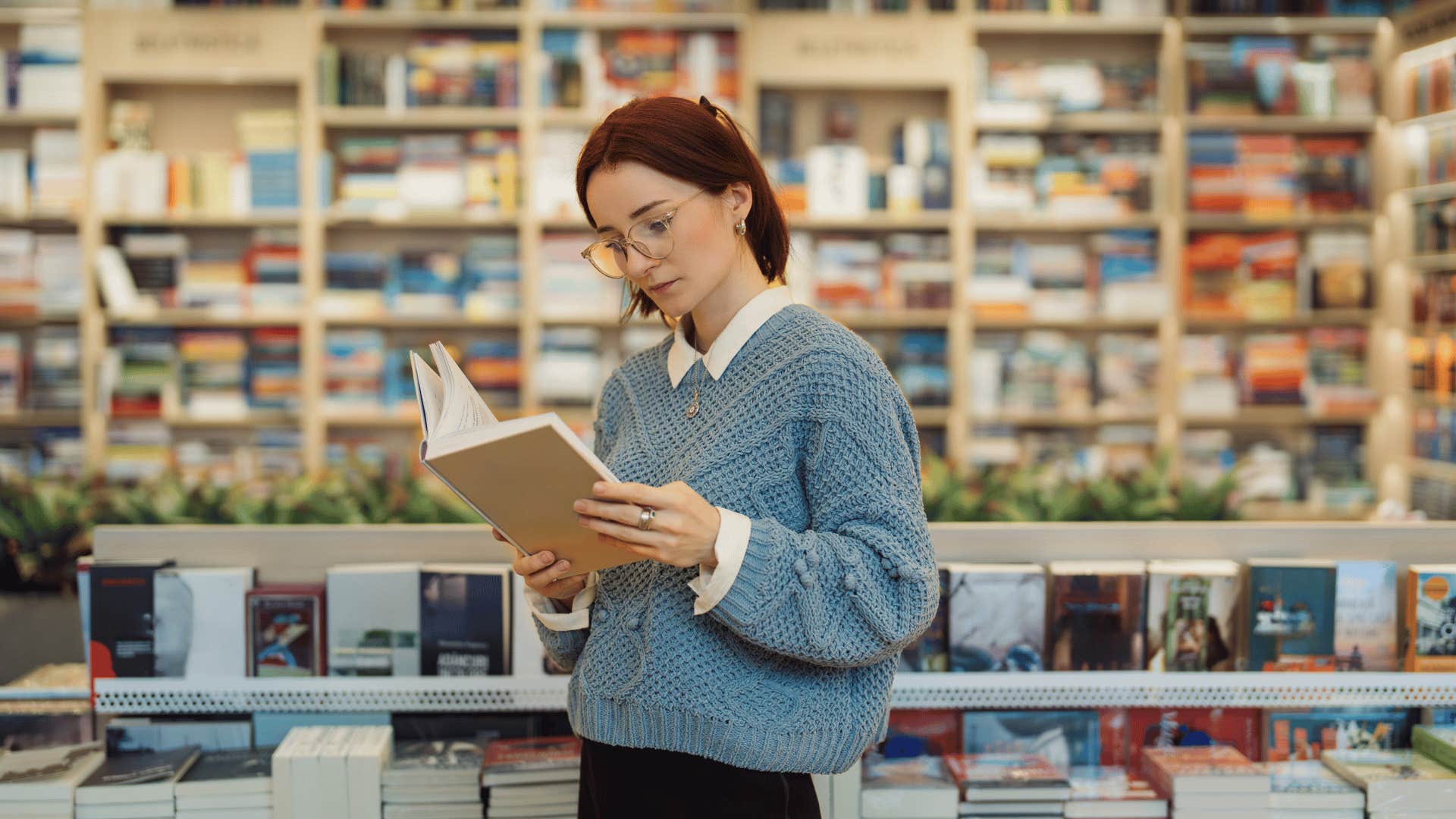 woman reading book in bookstore