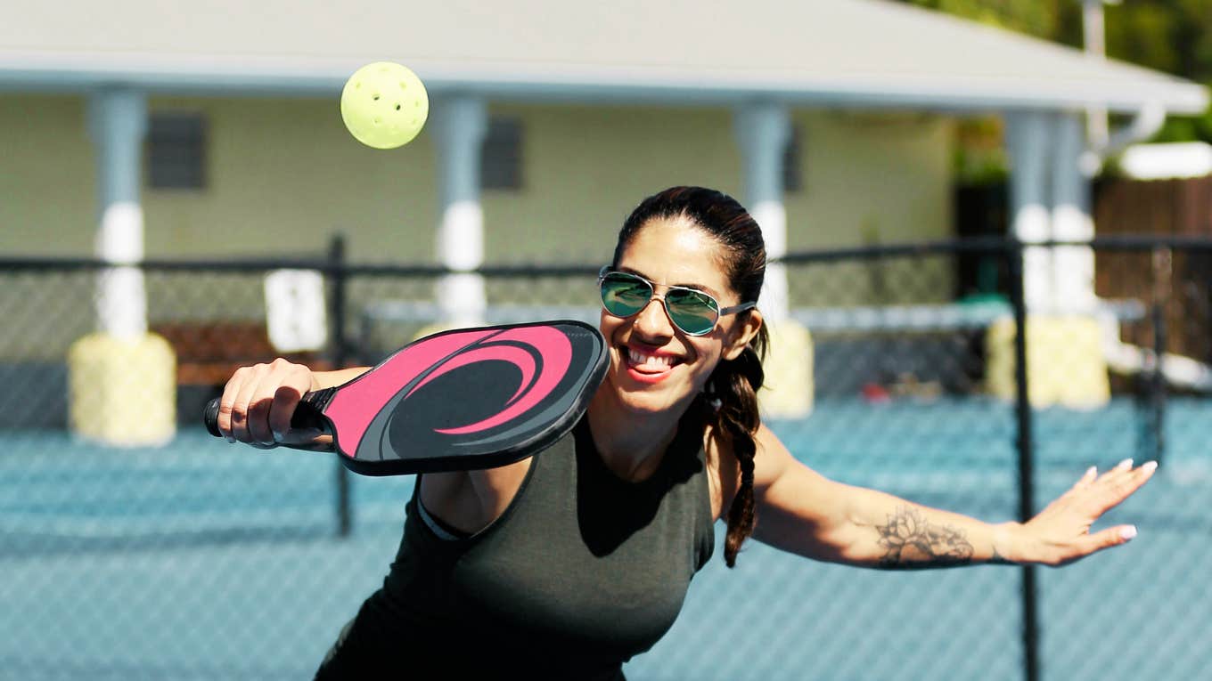 Woman playing pickleball with partner.