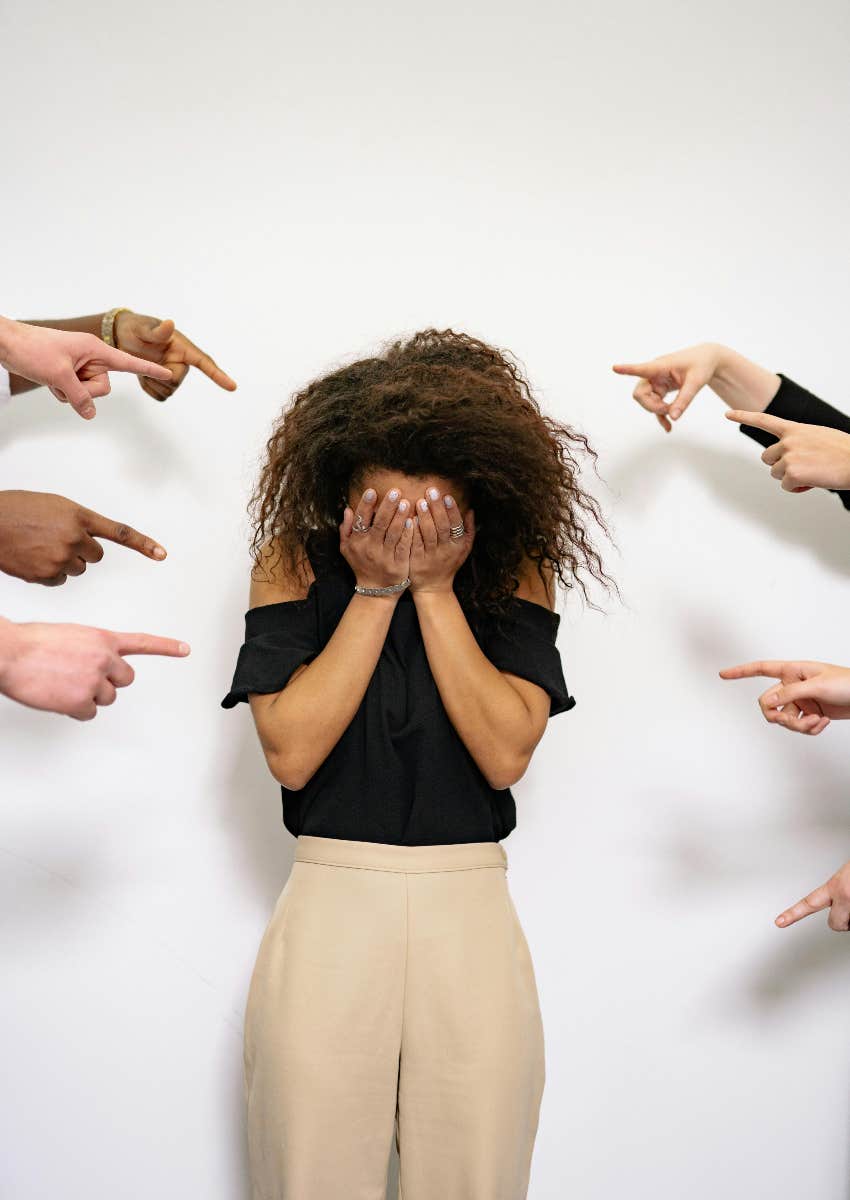 embarrassed woman with fingers pointing at her