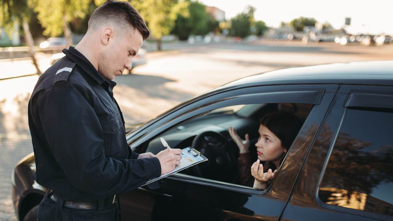 Police officer writing woman a ticket