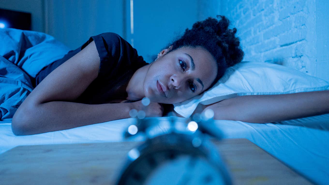 Woman who can't fall asleep because of racing thoughts