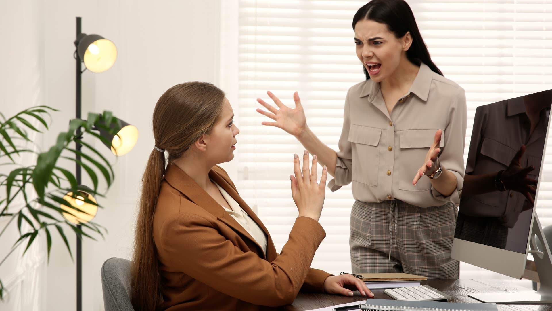 Woman yelling at her co-worker in an office.