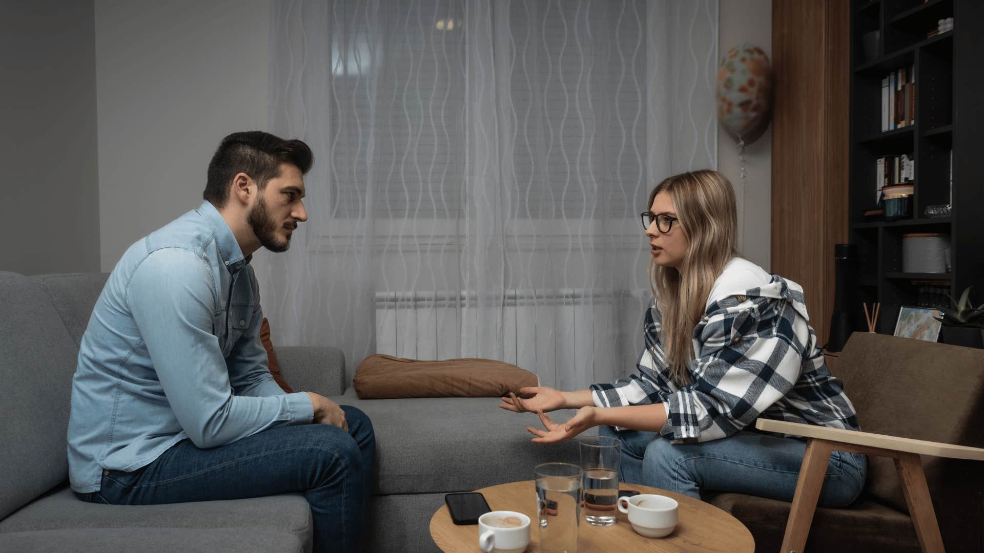 couple talking seriously while sitting across from each other