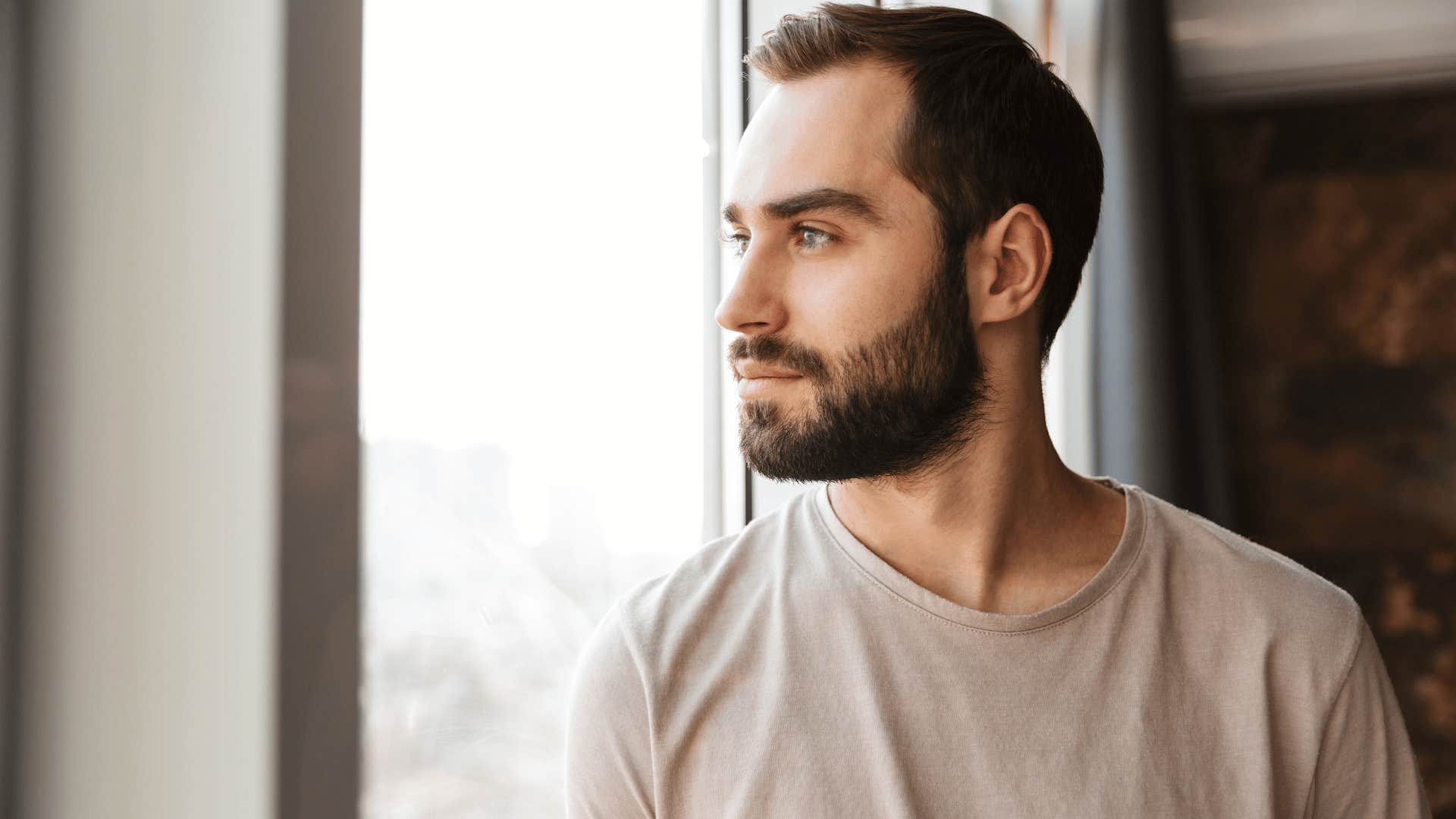 emotionless man looking out the window