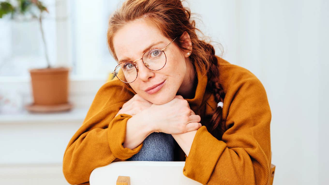 Introvert woman sitting on chair at home, perfectly content.