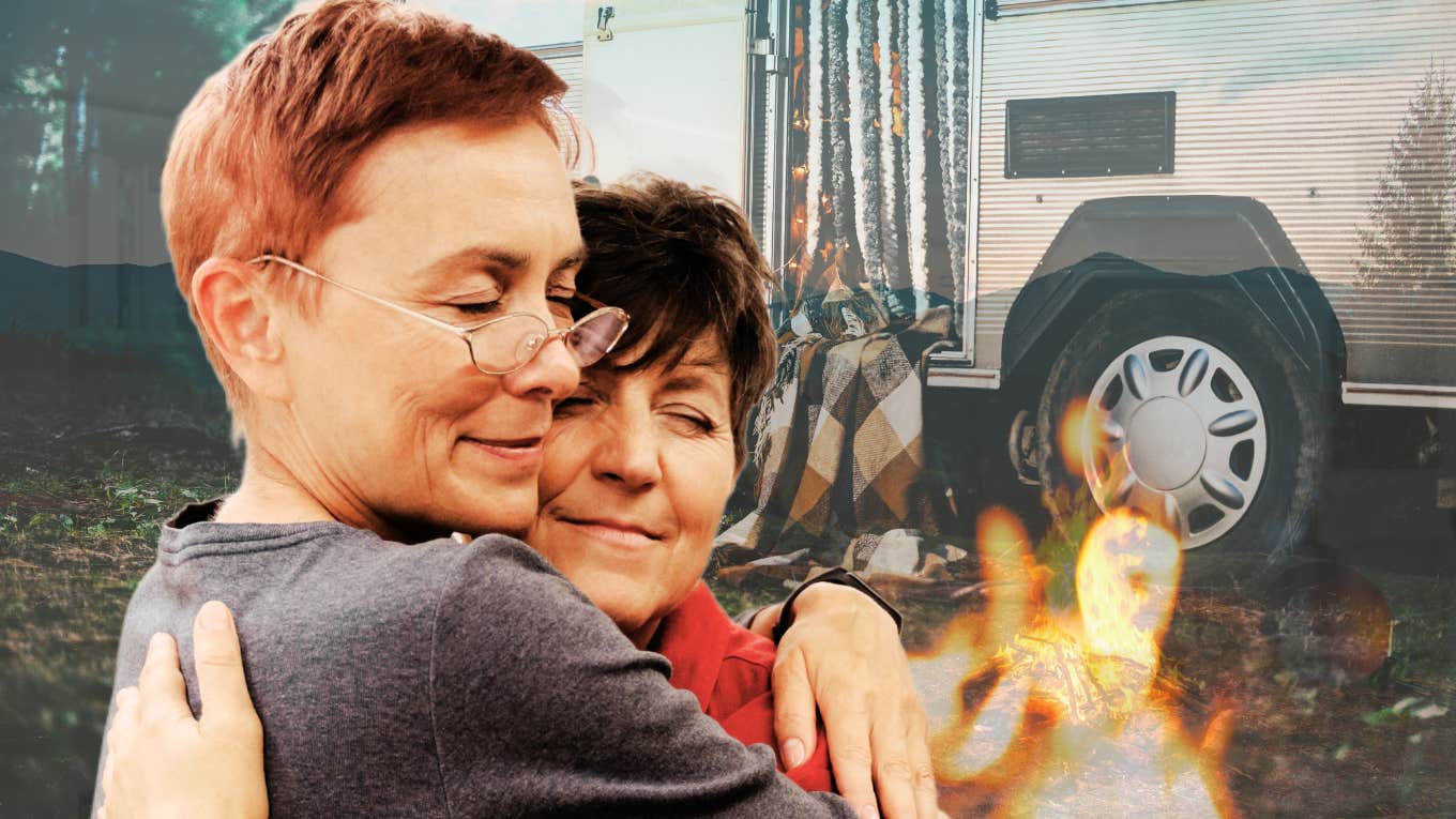 Retired couple embracing by campfire while traveling in trailer