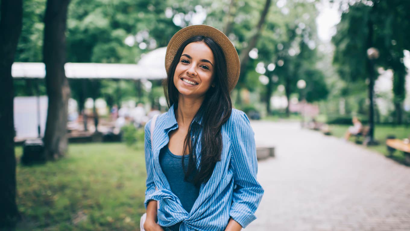 woman smiling in park wearing a hat