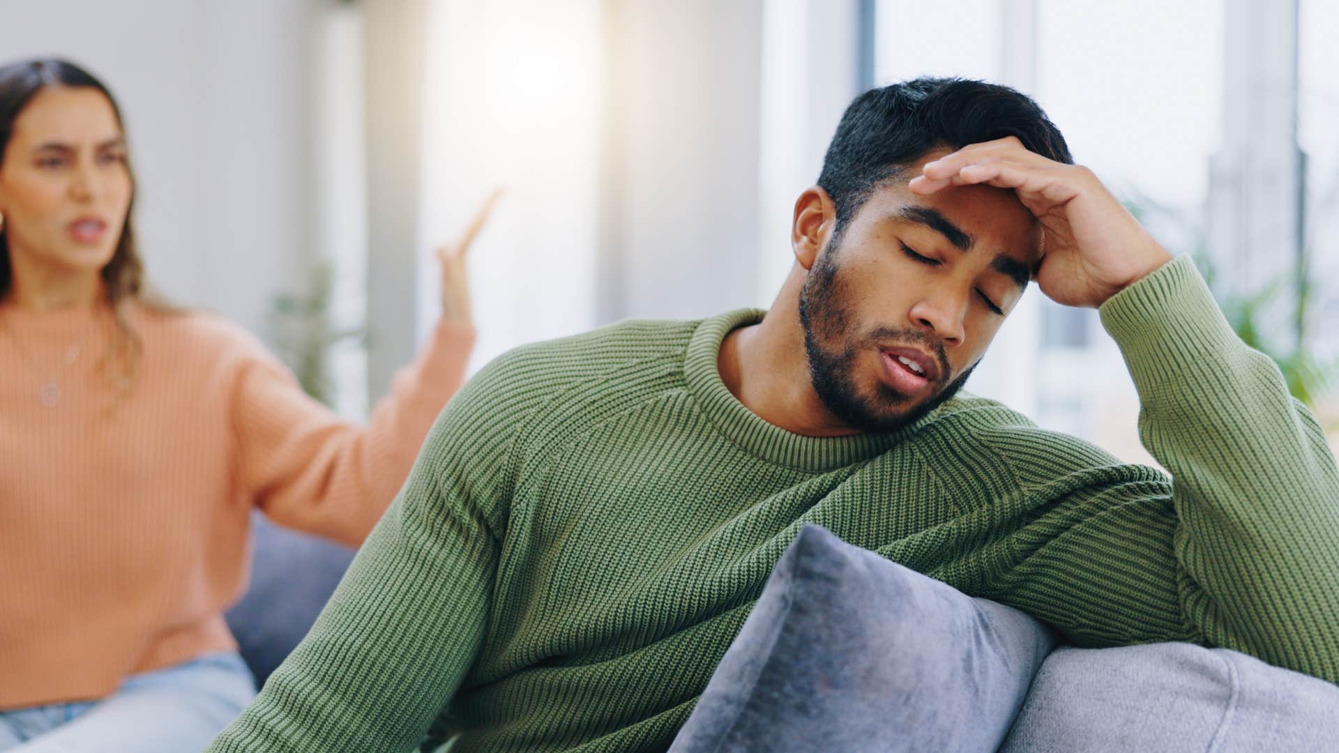 man not listening while his wife talks to him