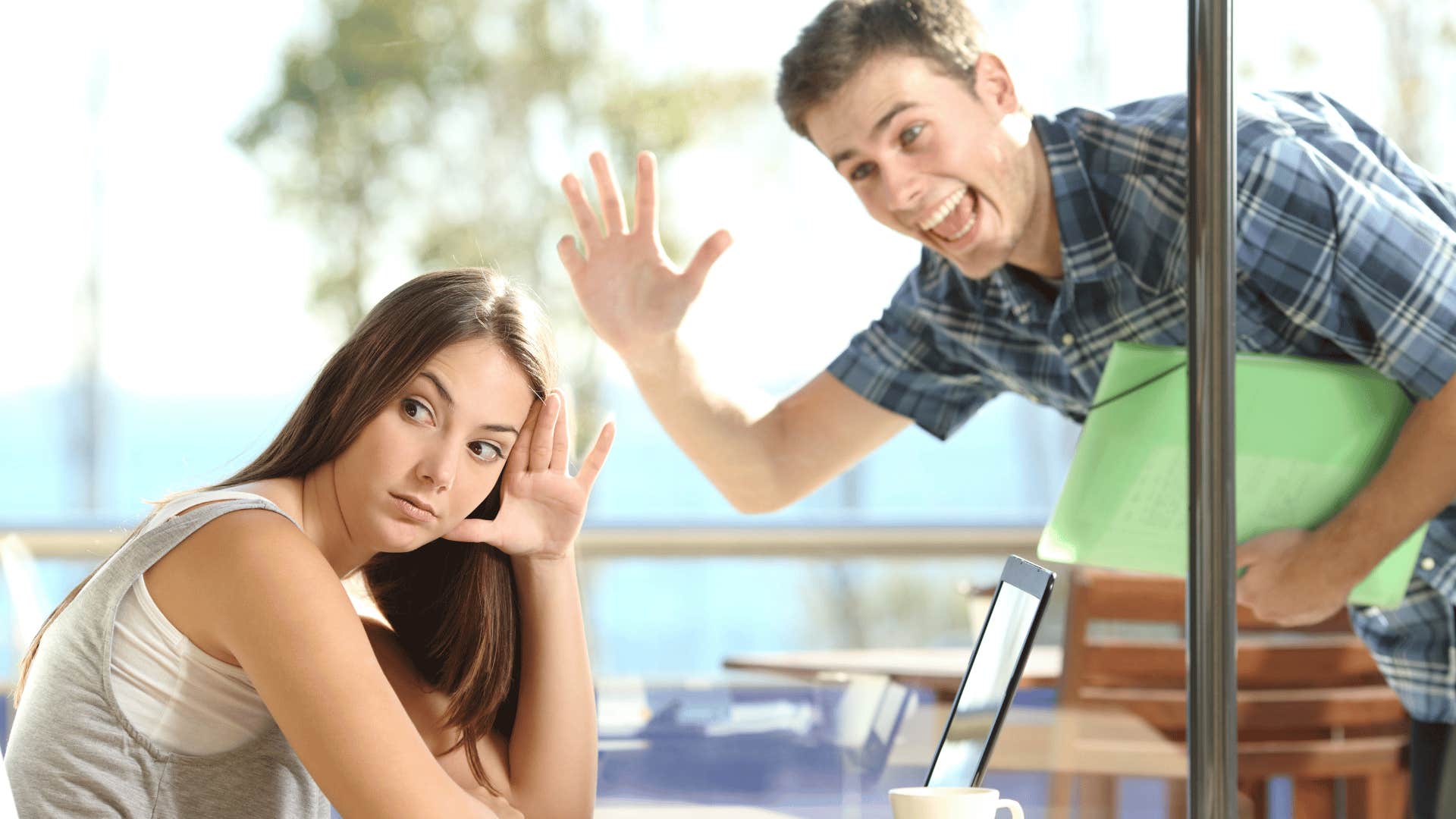 woman ignoring man trying to get her attention