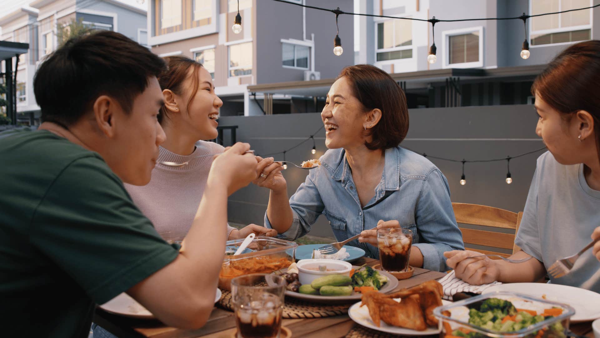 Family shares meal together on balcony 