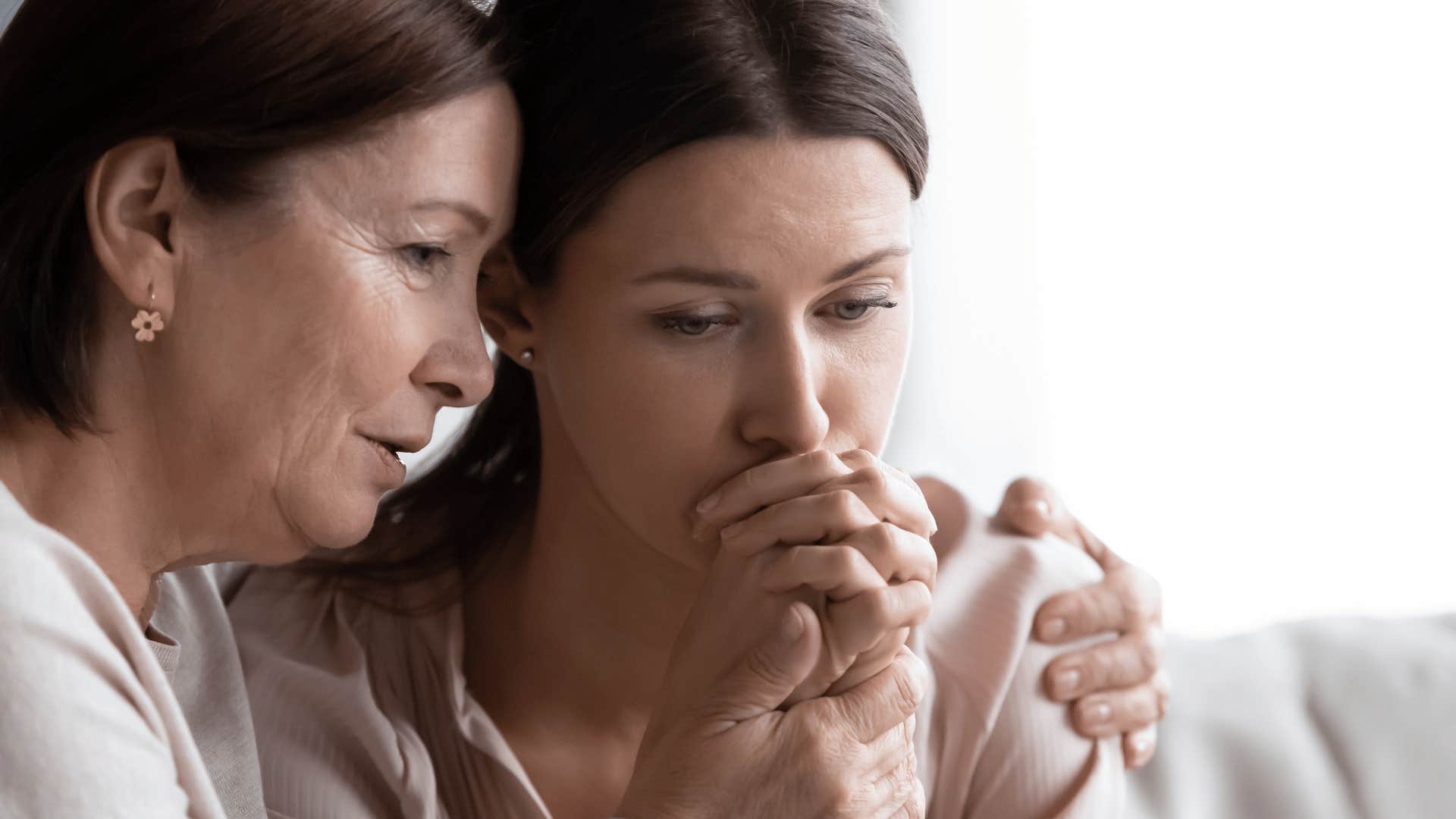 mother comforting adult daughter