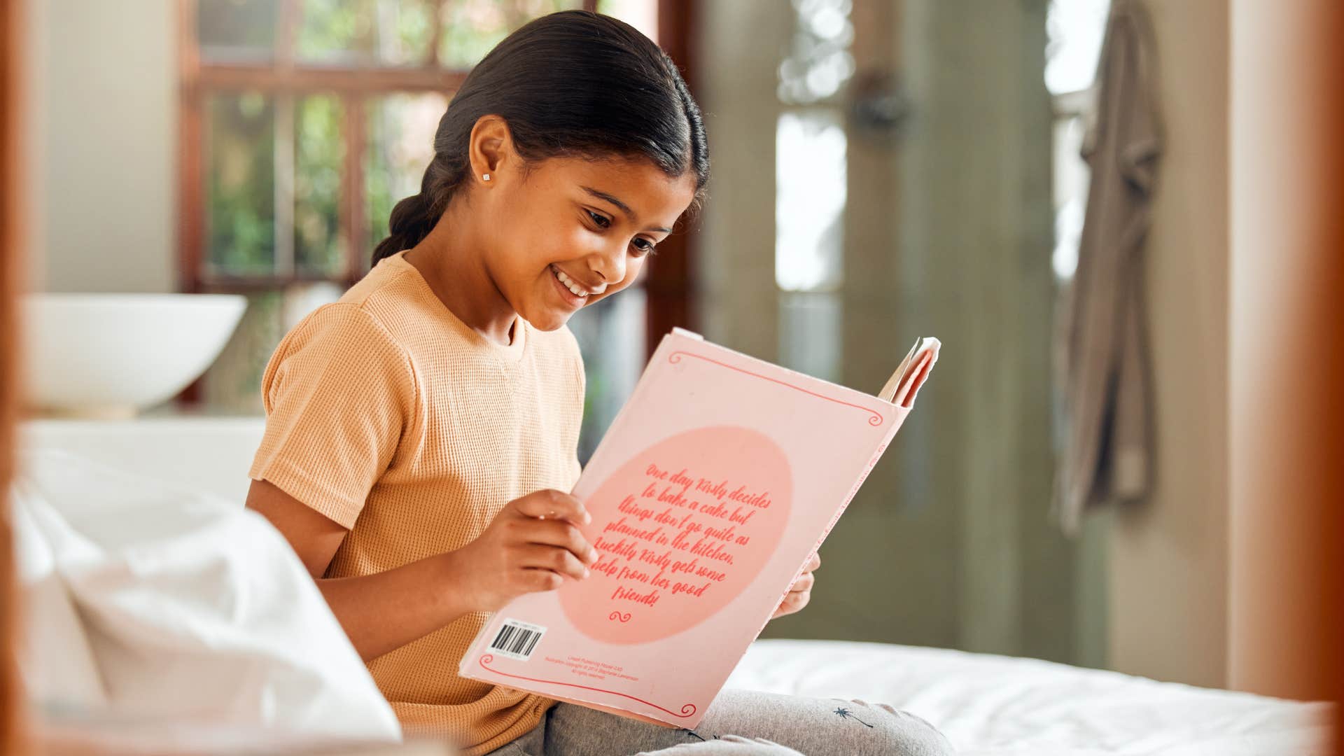 little girl happily reading by herself