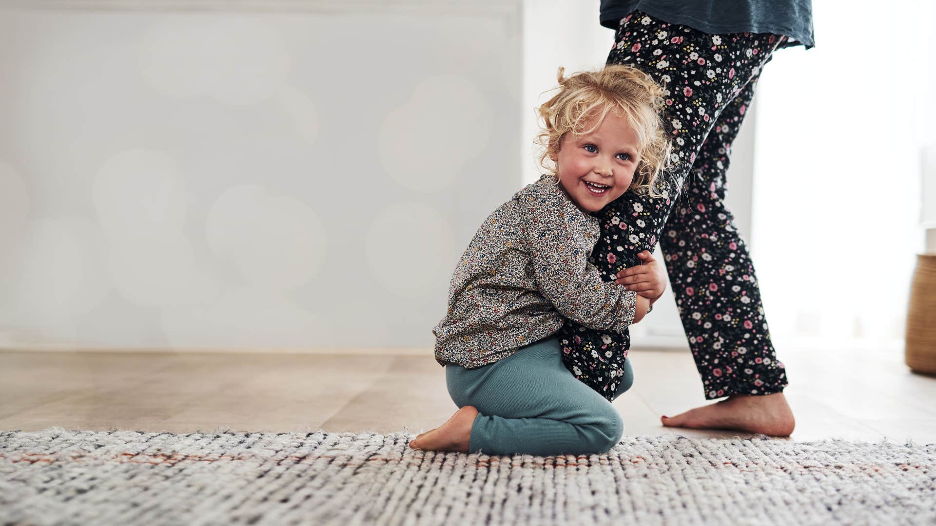 little girl clinging to mother's leg