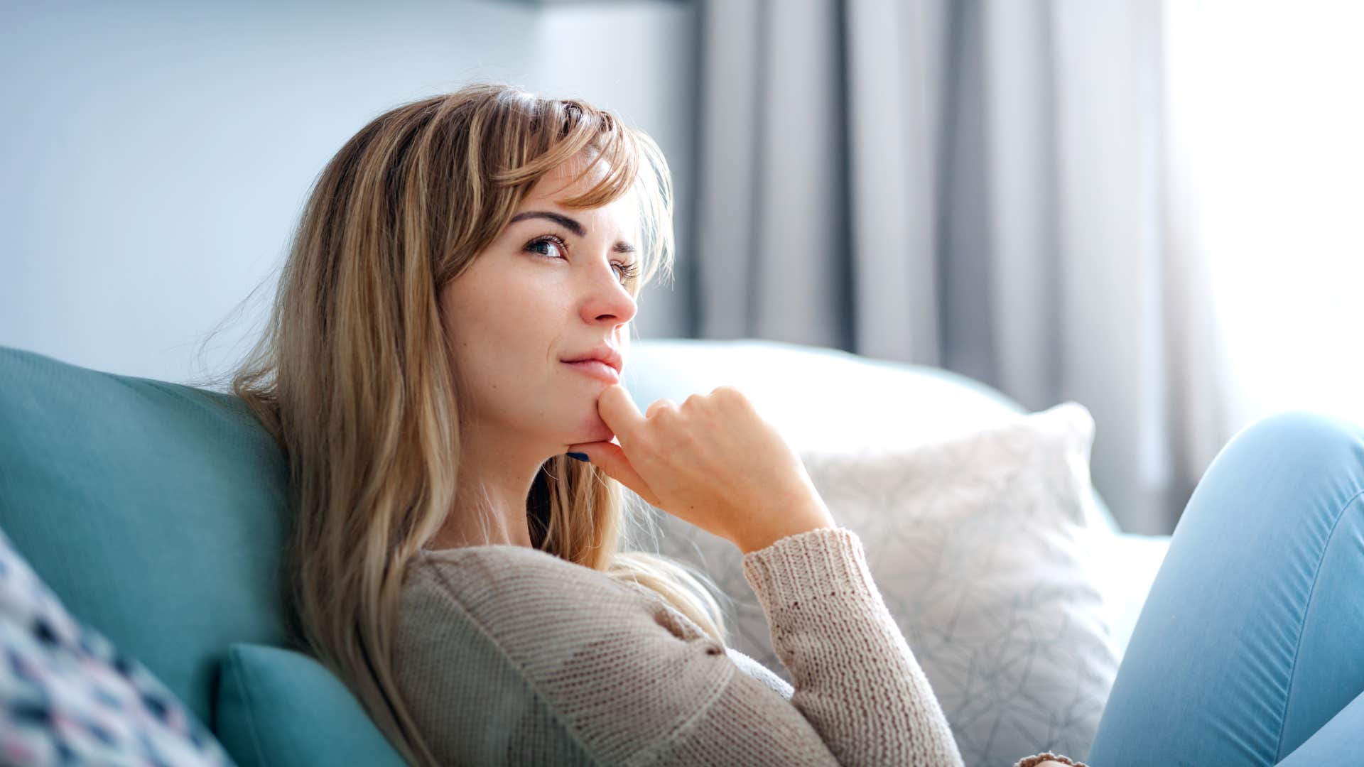 deep thinking woman sitting on a couch