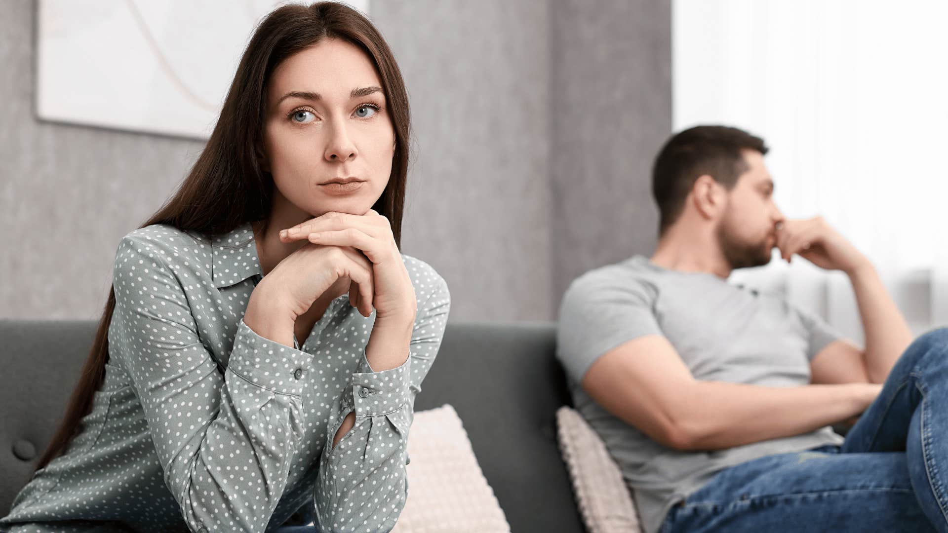 couple ignoring each other on couch