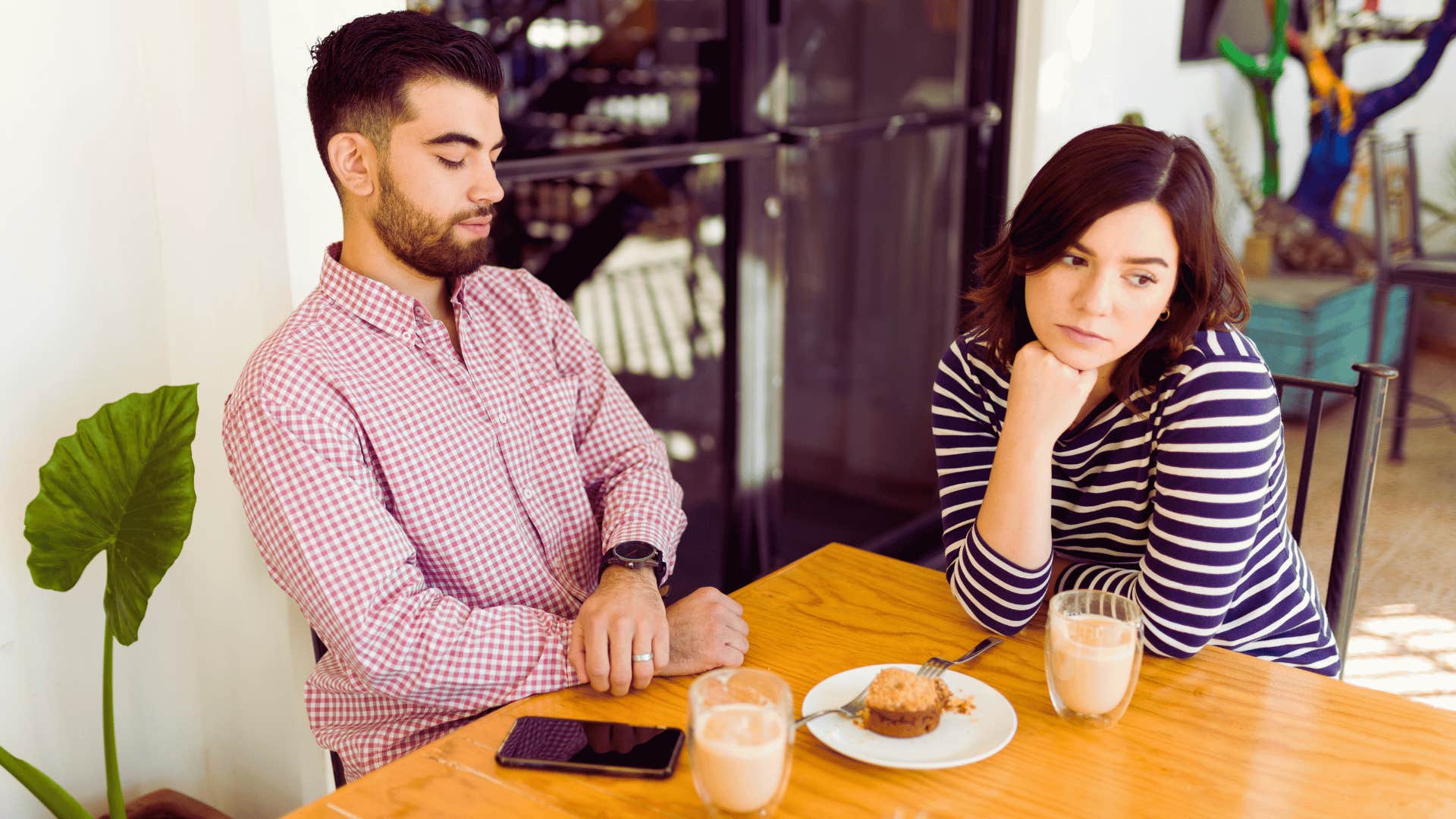 distracted couple having breakfast