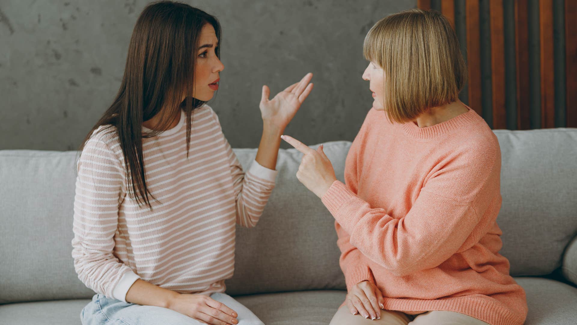 Adult woman arguing with her mother on a couch.