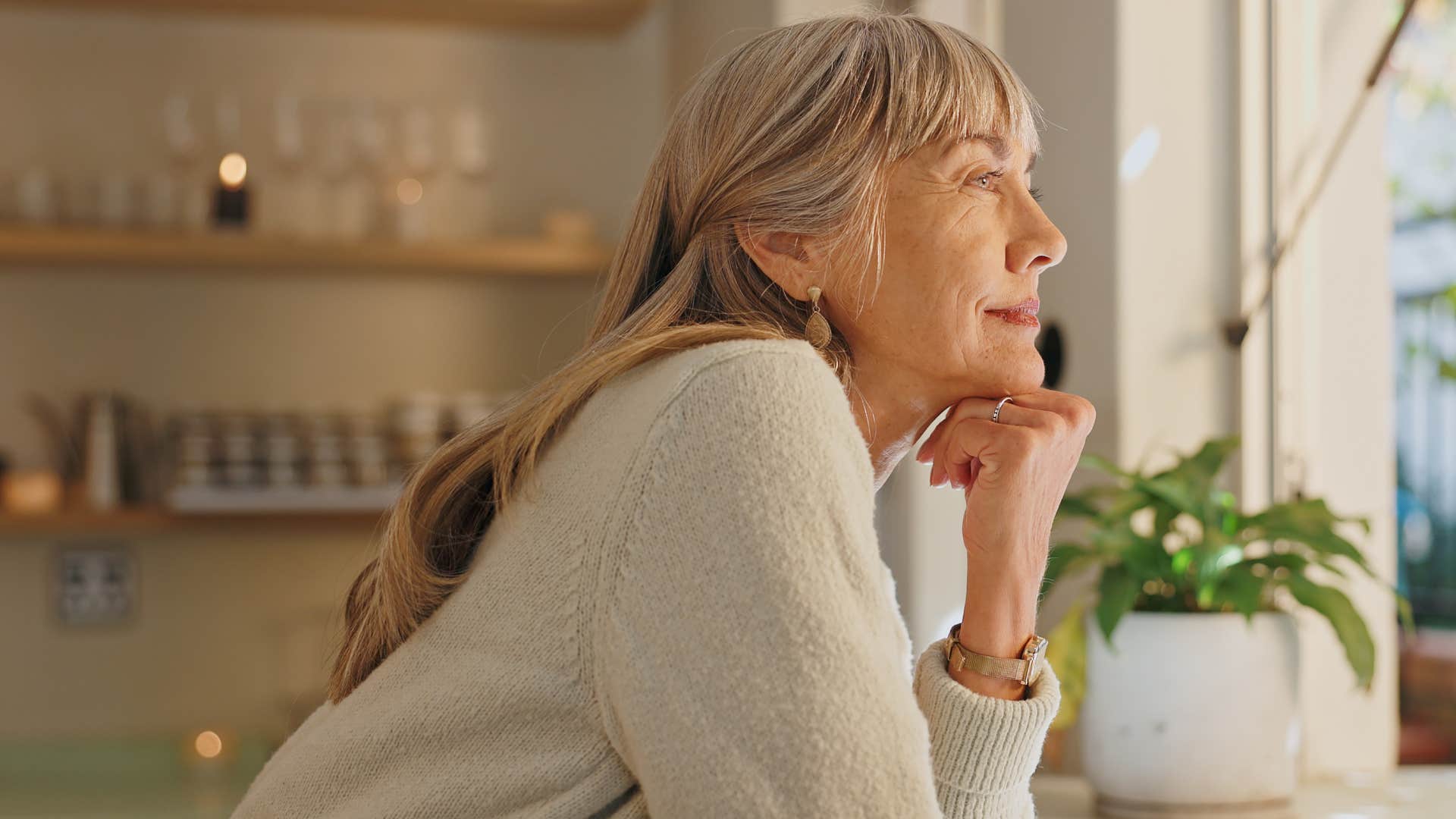 Woman smiling and looking out a window.