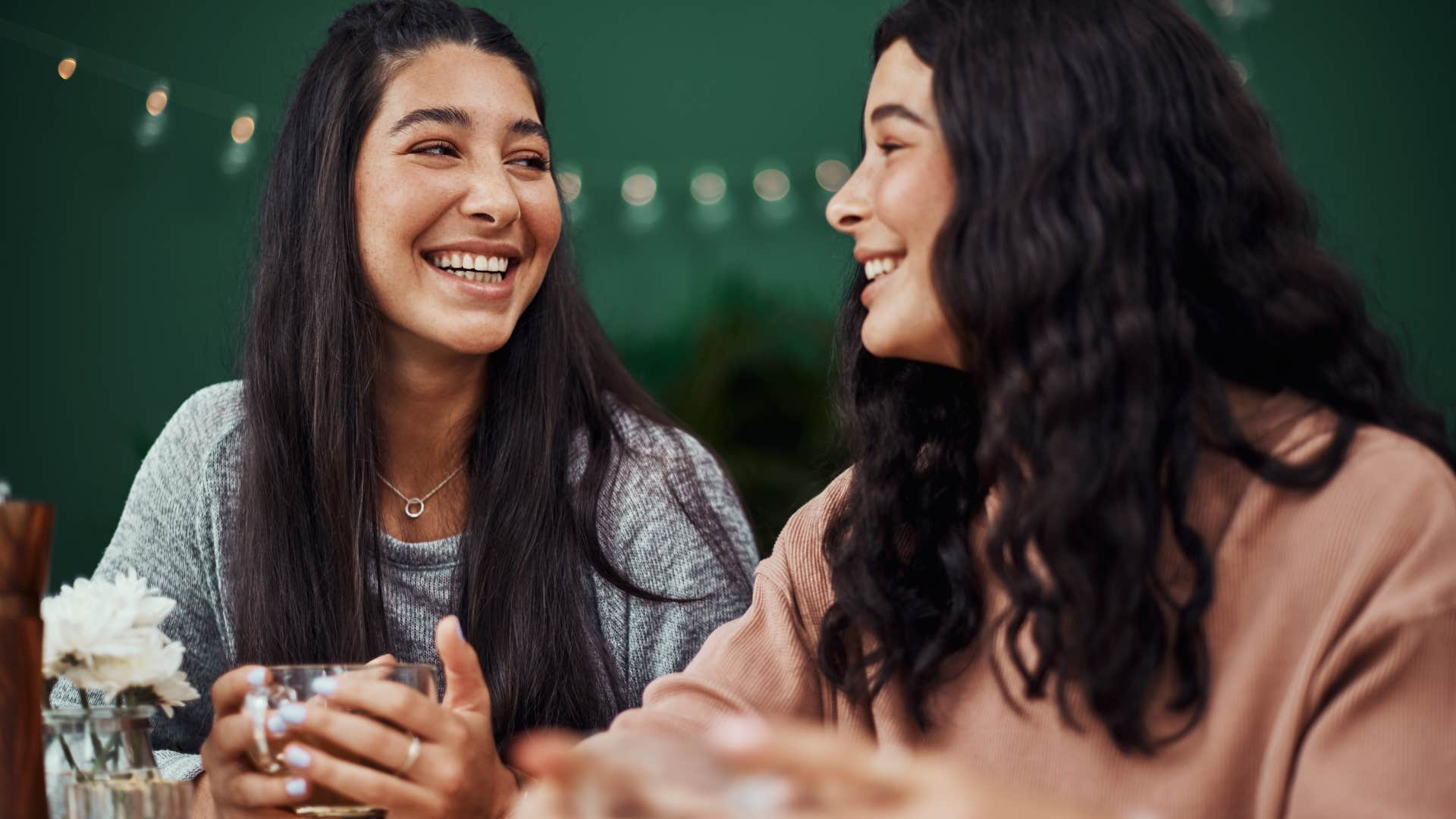 Two women smiling and talking to each other.